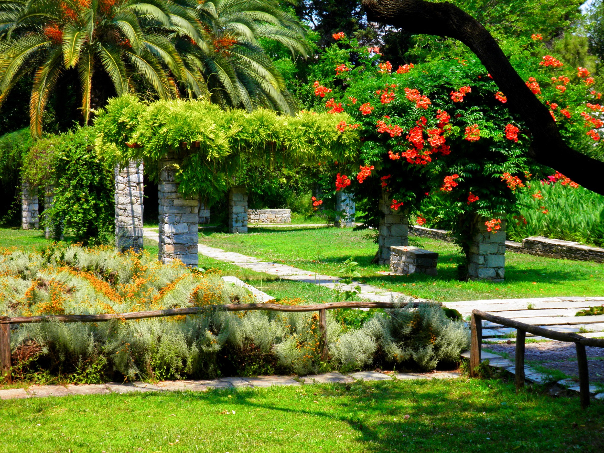 Stone pergolas and blooming trees in a park HD Wallpaper