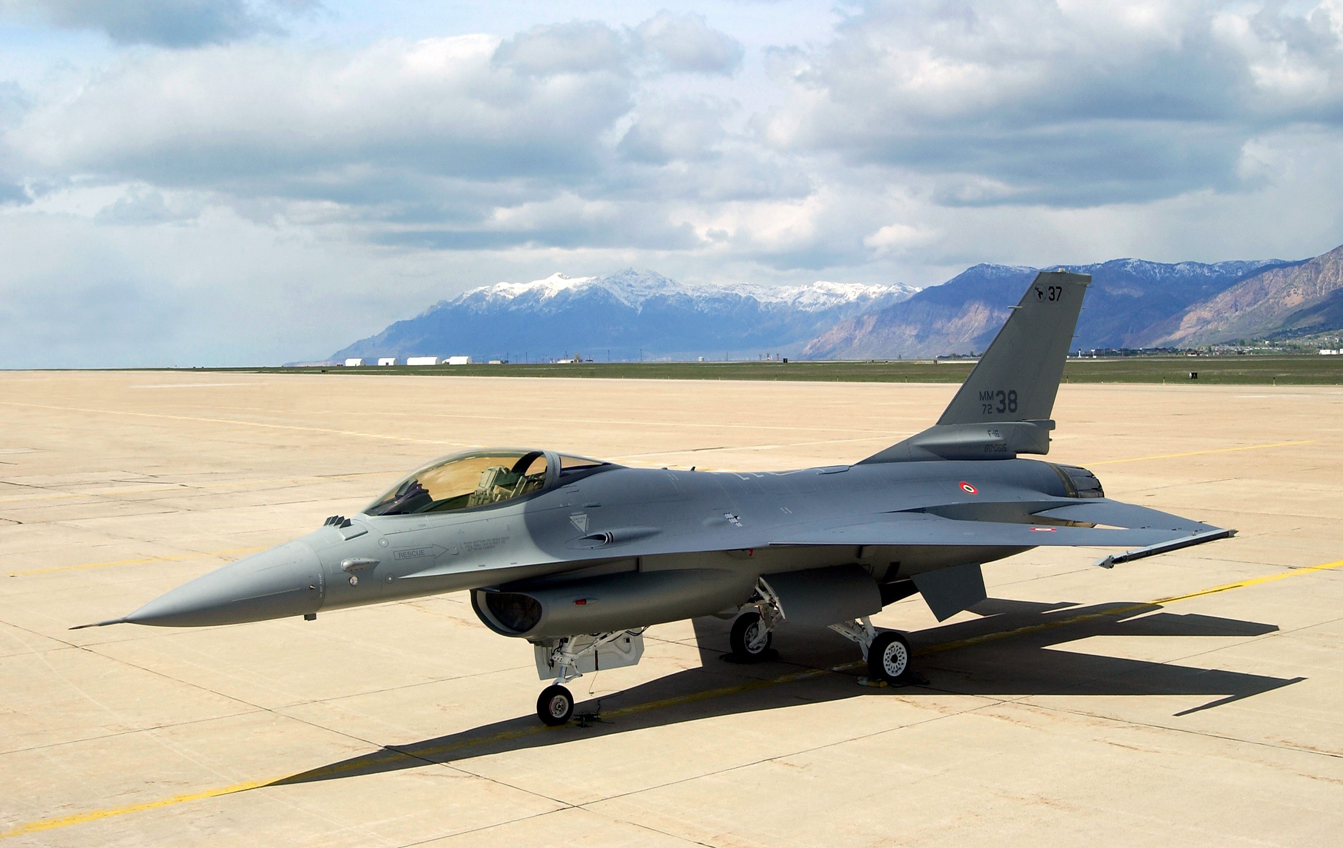 Gray F-16 Fighting Falcon on Tarmac with Mountains HD Wallpaper