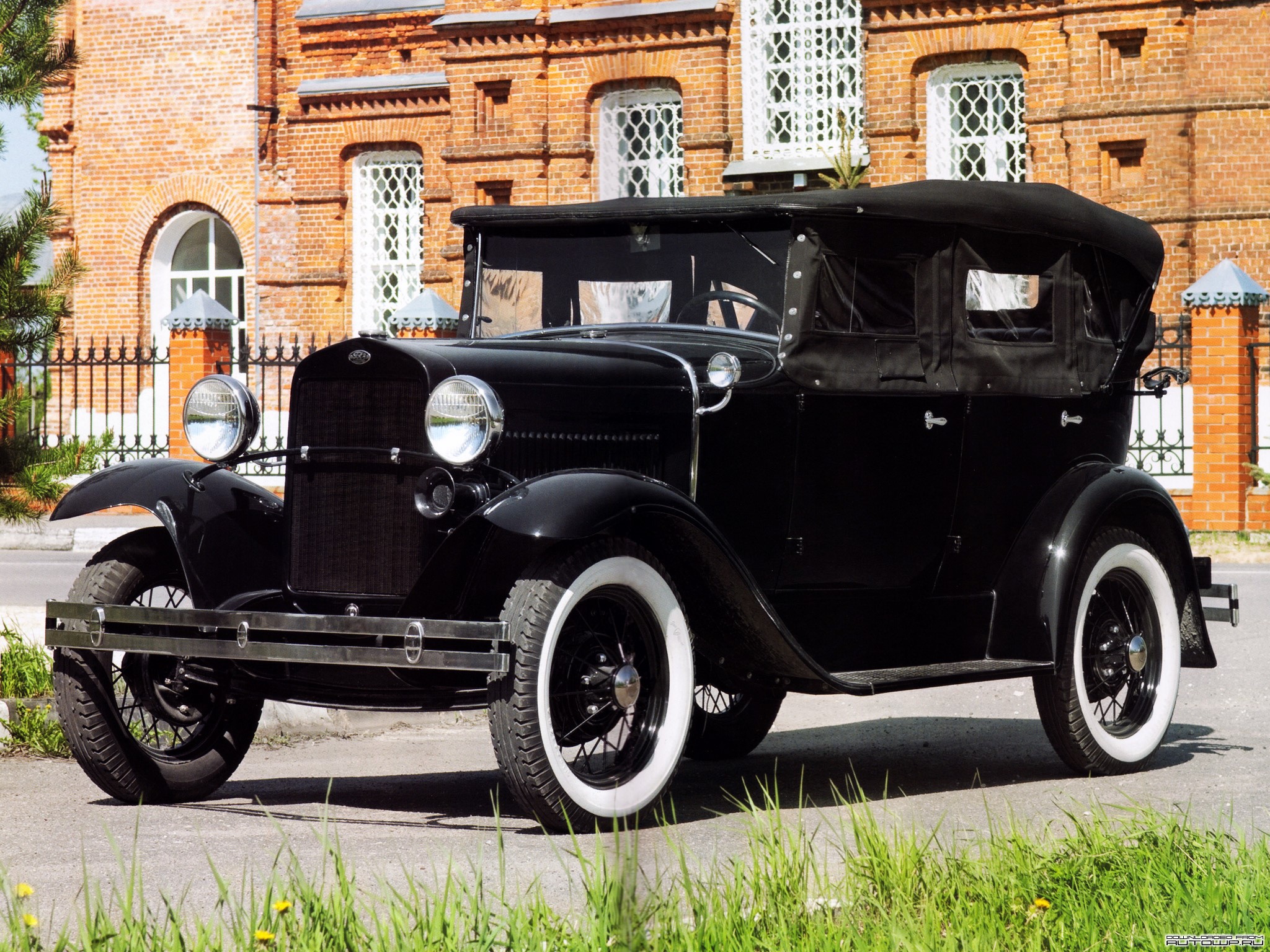 Black Ford Model A convertible parked in front of a brick building HD Wallpaper