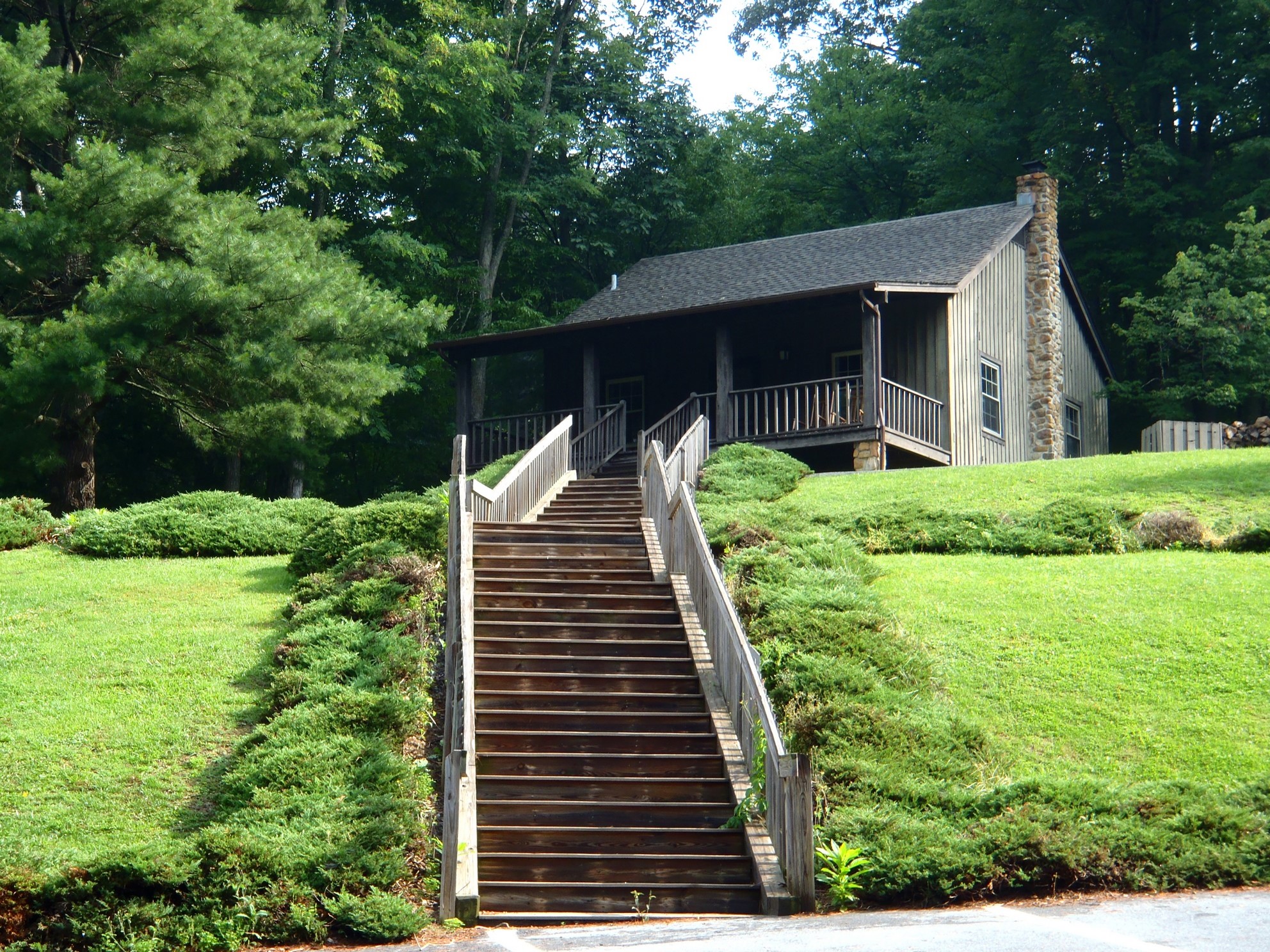 Wooden cabin with stone chimney and stairs at Roan Mountain State Park HD Wallpaper