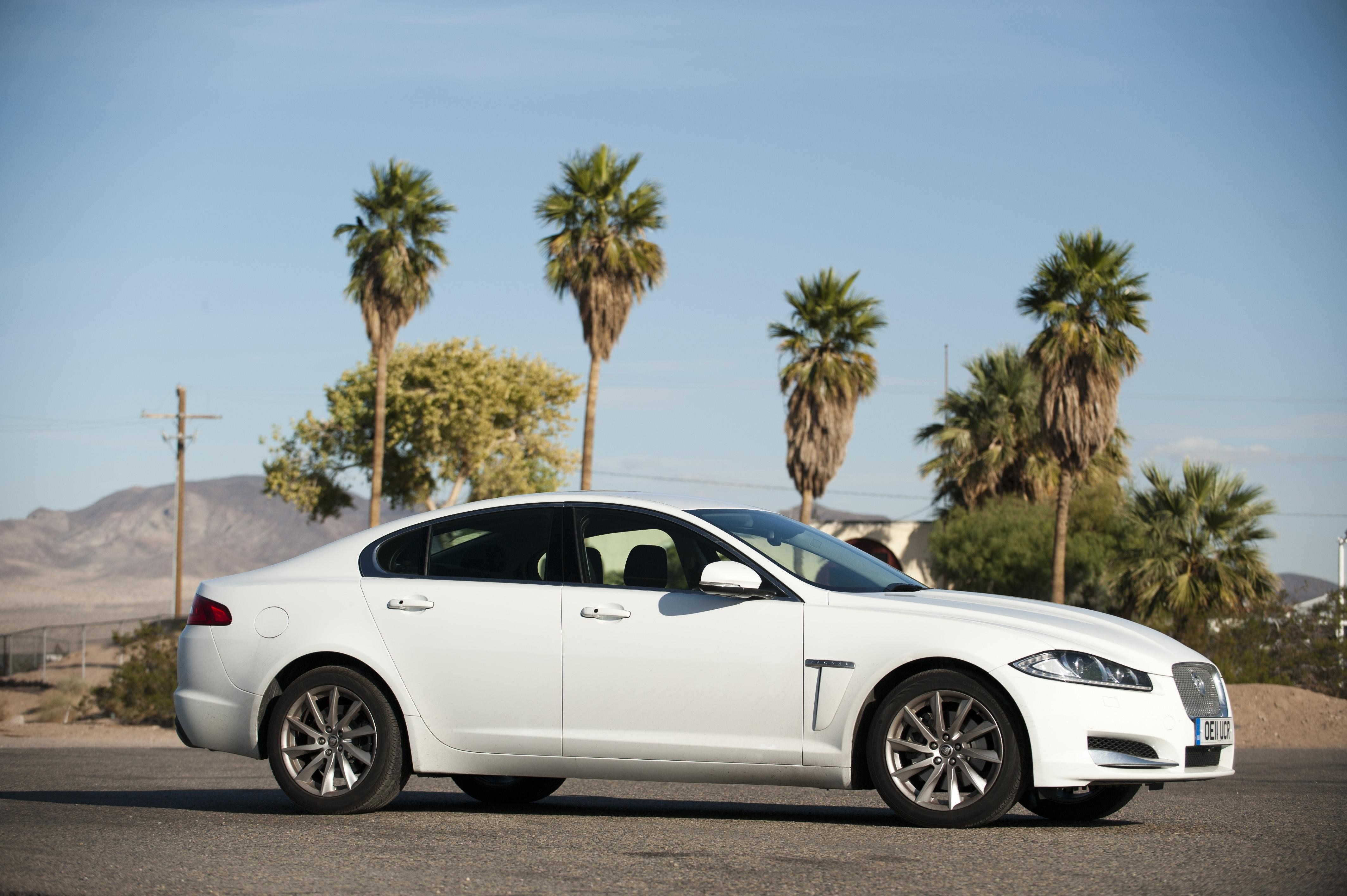 White Jaguar Sedan in Desert Landscape HD Wallpaper