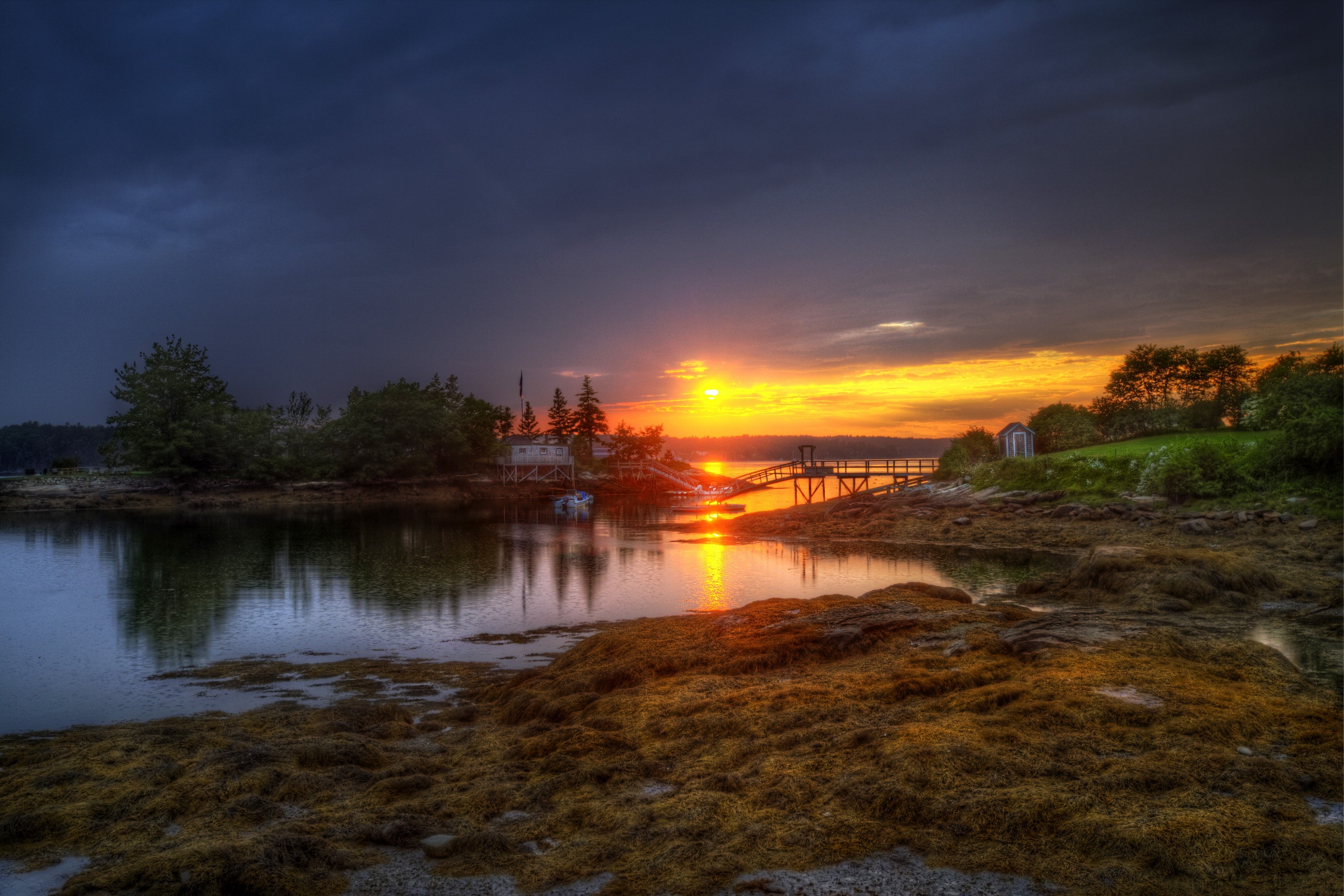 Sunset over a coastal village with a dock HD Wallpaper