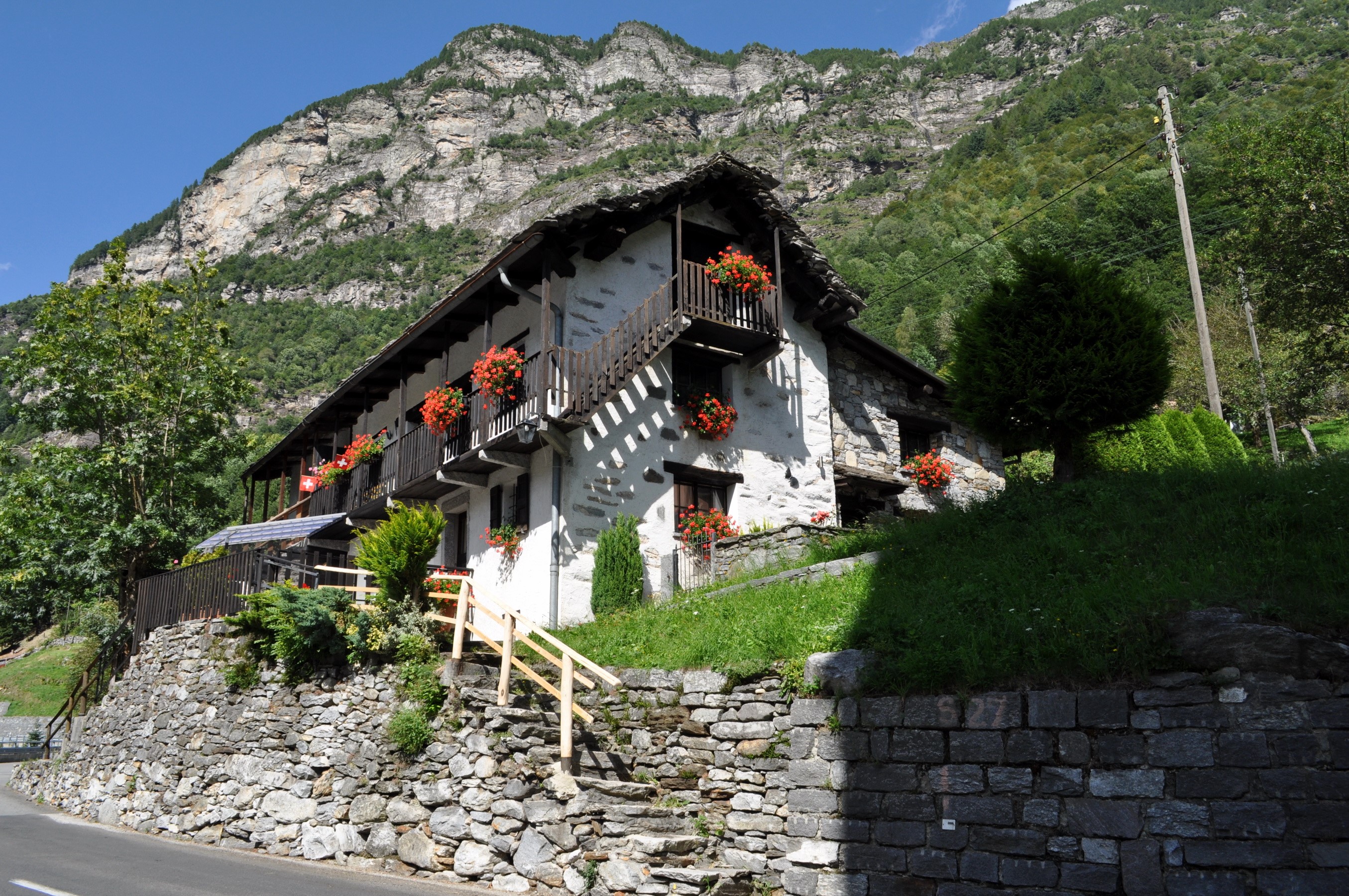 Stone house with balconies and flowers in Frasco, Ticino, Switzerland HD Wallpaper