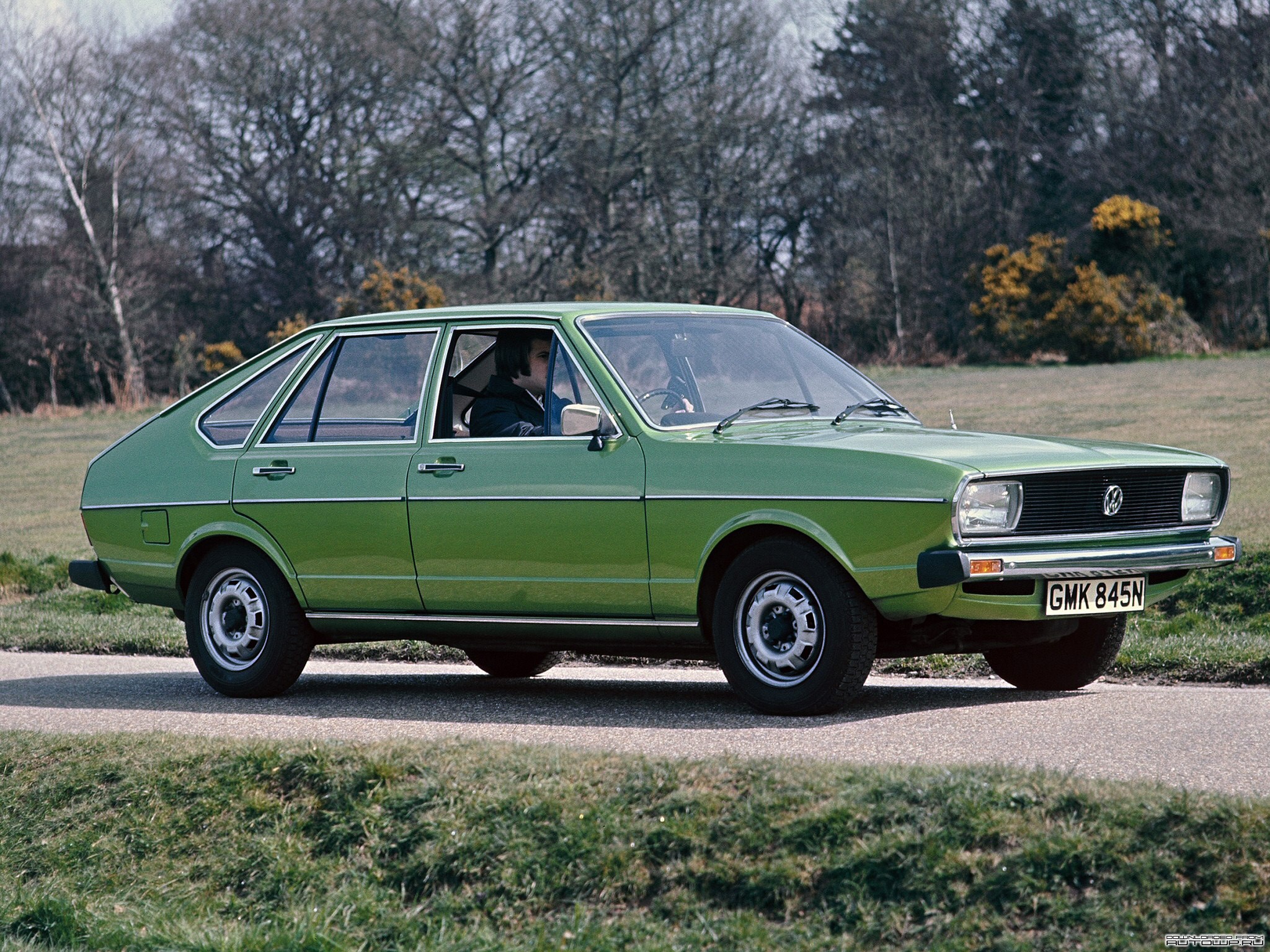 Green Volkswagen Passat driving on a road HD Wallpaper