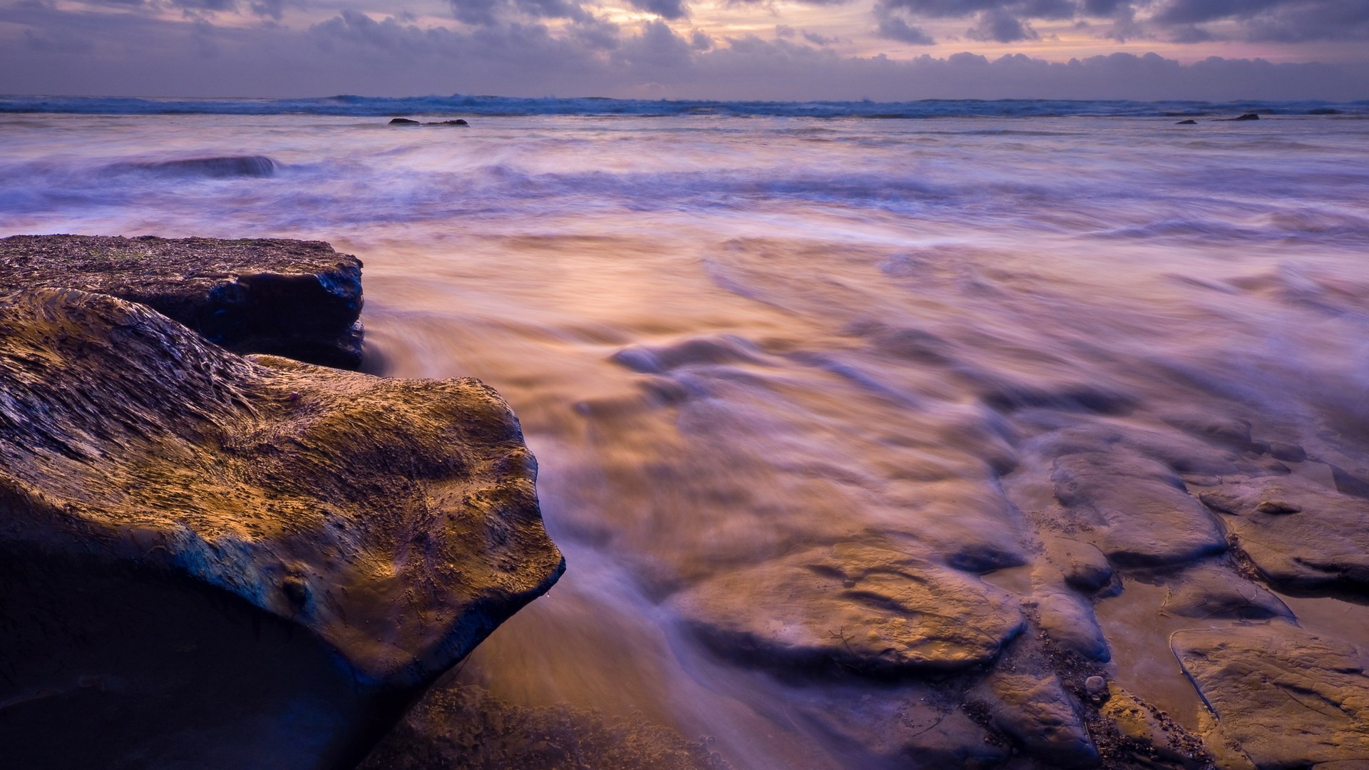 Long exposure of waves crashing on rocks at sunset HD Wallpaper