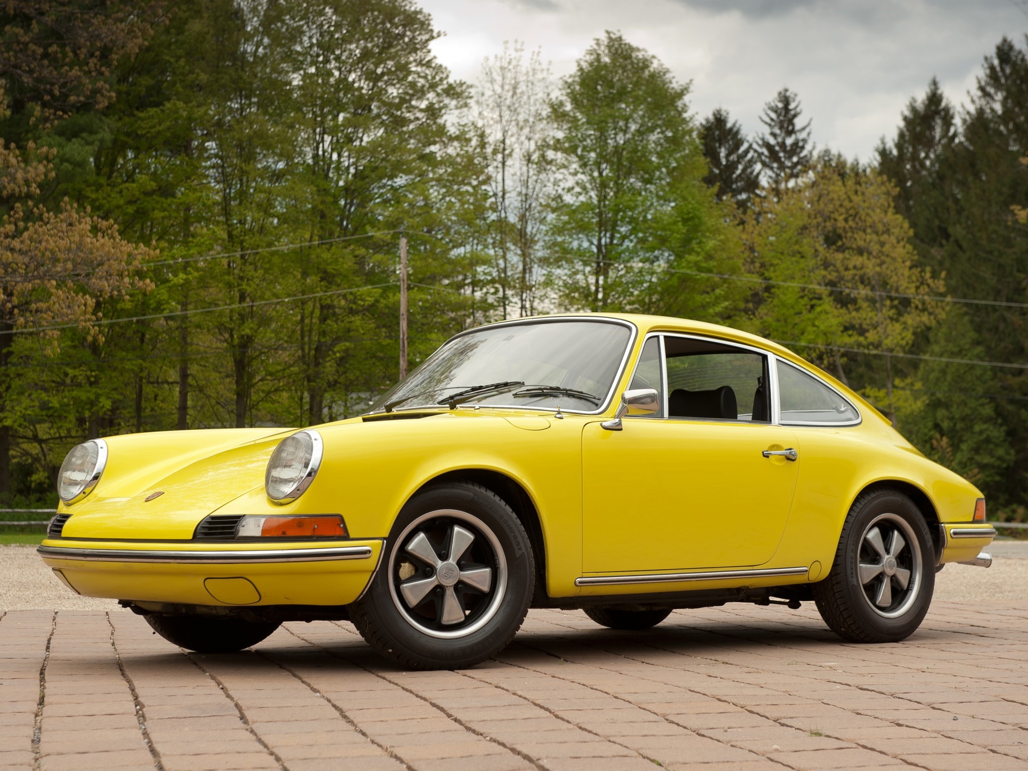 Yellow Porsche 911 parked on brick patio HD Wallpaper