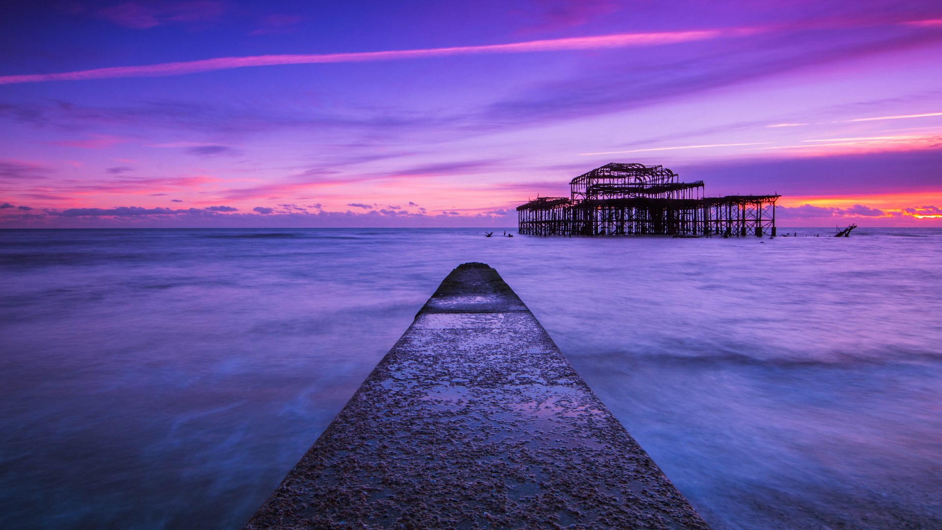 Ruined pier at sunset with purple and pink sky HD Wallpaper