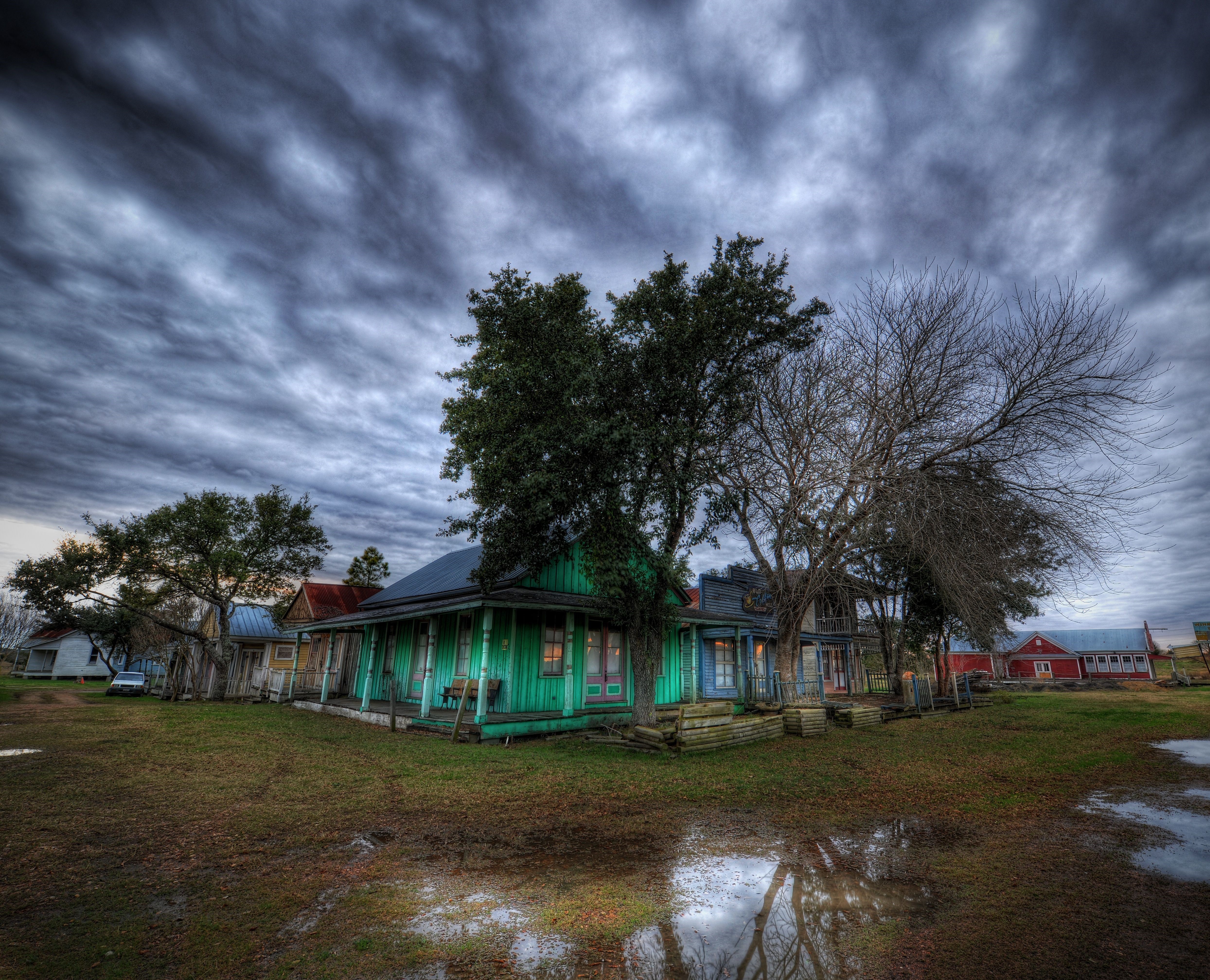 Old houses in a rural setting under a cloudy sky HD Wallpaper