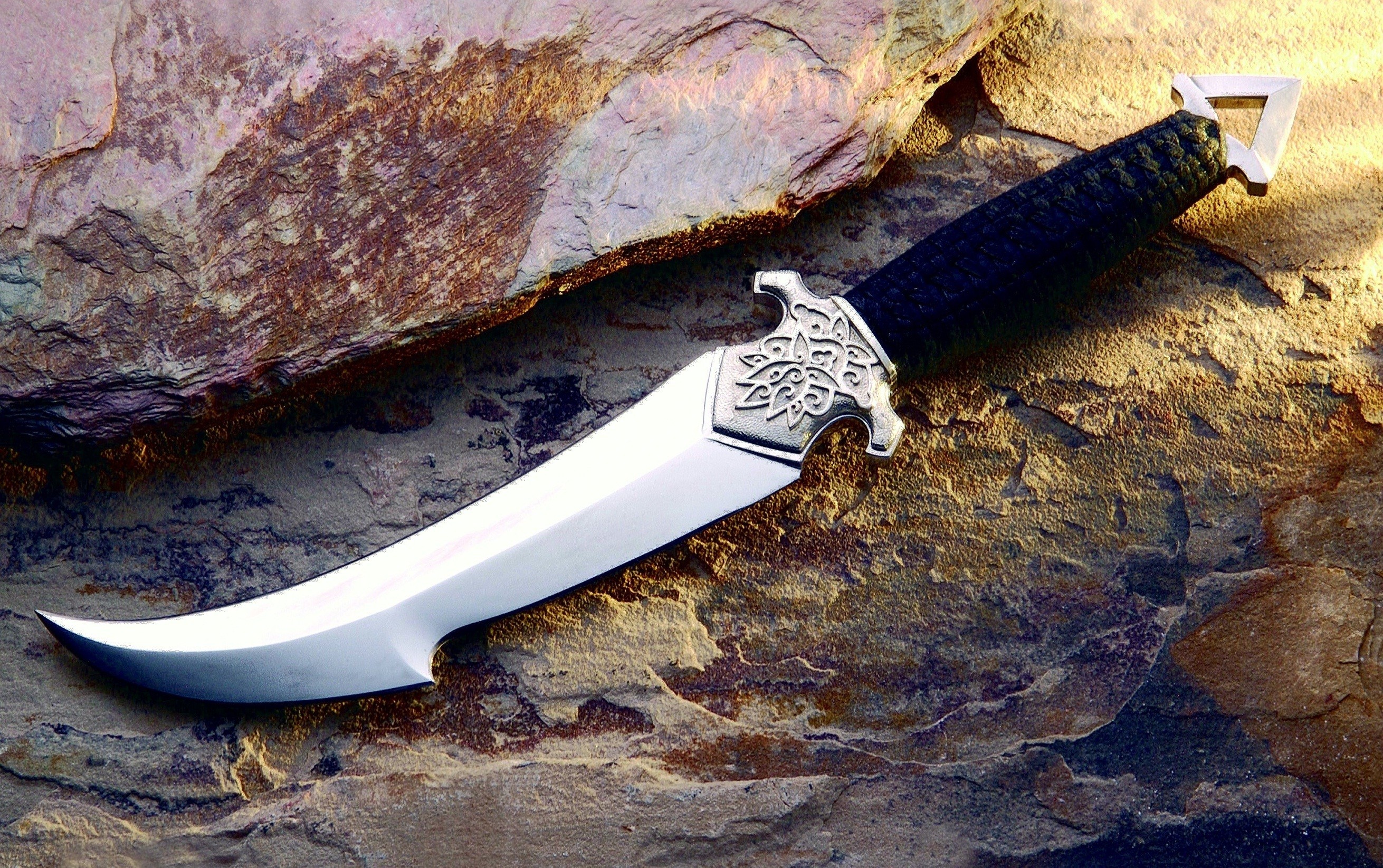 Decorative knife with ornate hilt on textured rock HD Wallpaper
