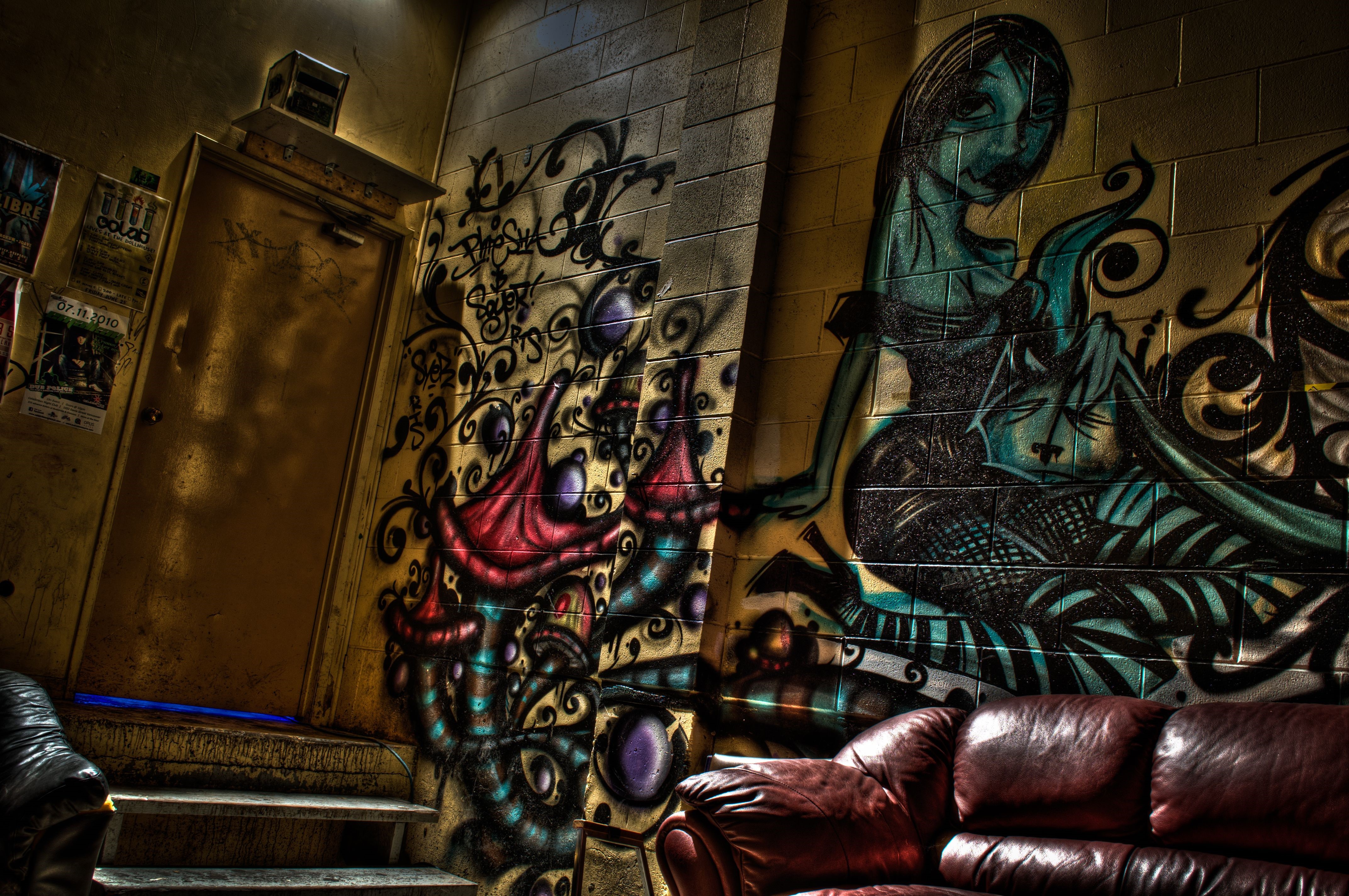 Graffiti-covered interior with leather couch HD Wallpaper