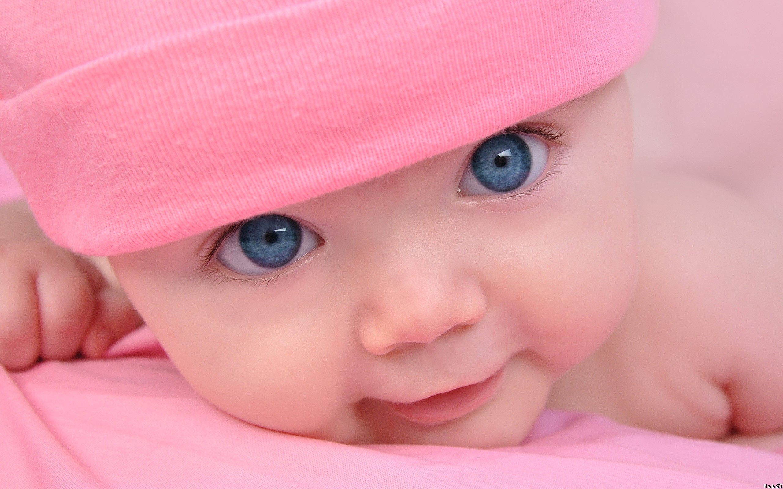 Baby with blue eyes wearing a pink hat HD Wallpaper