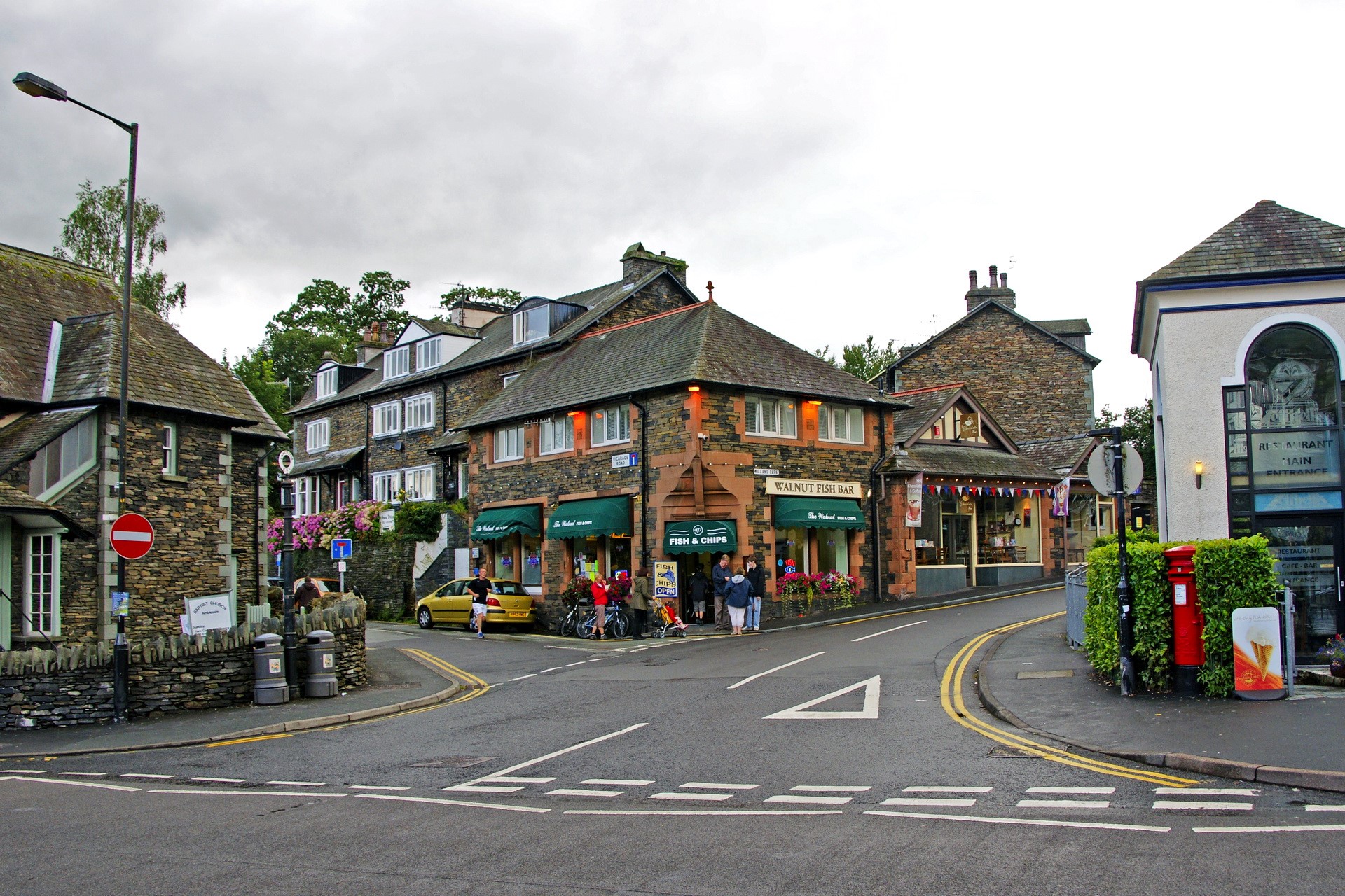 Street scene in the United Kingdom with shops and houses HD Wallpaper