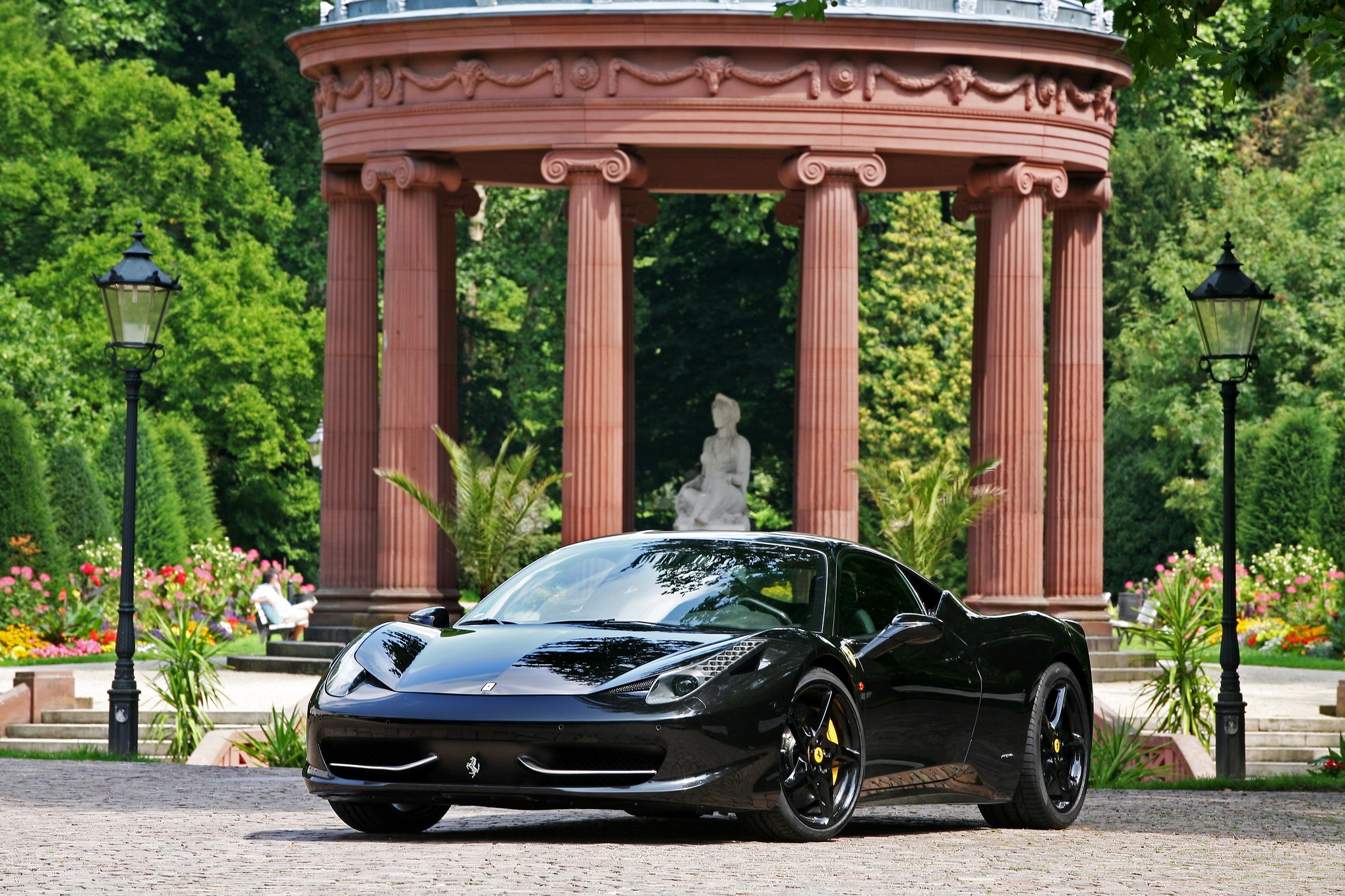 Black Ferrari parked in a garden with a gazebo HD Wallpaper
