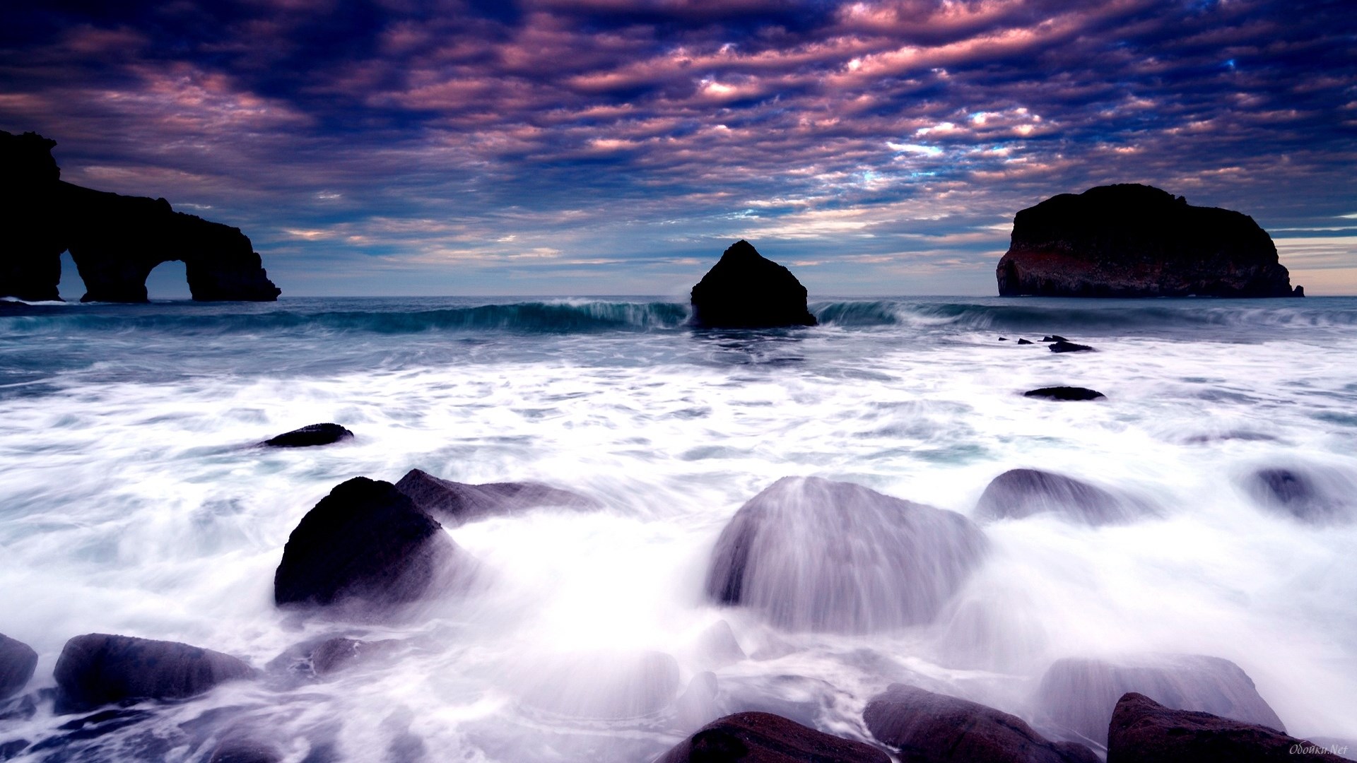 Waves crashing on rocks at sunset with archway HD Wallpaper