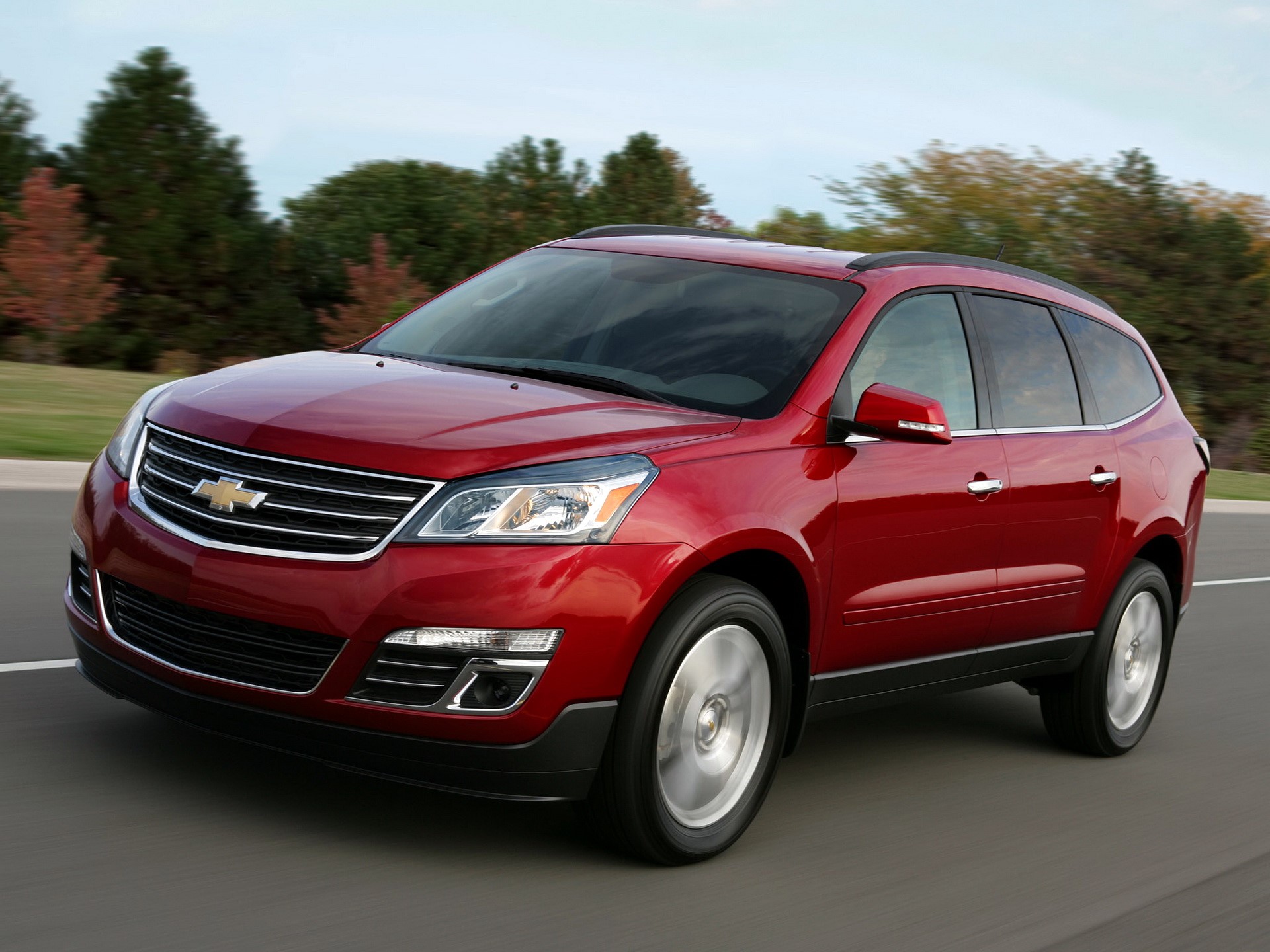 Red Chevrolet Traverse driving on a road HD Wallpaper