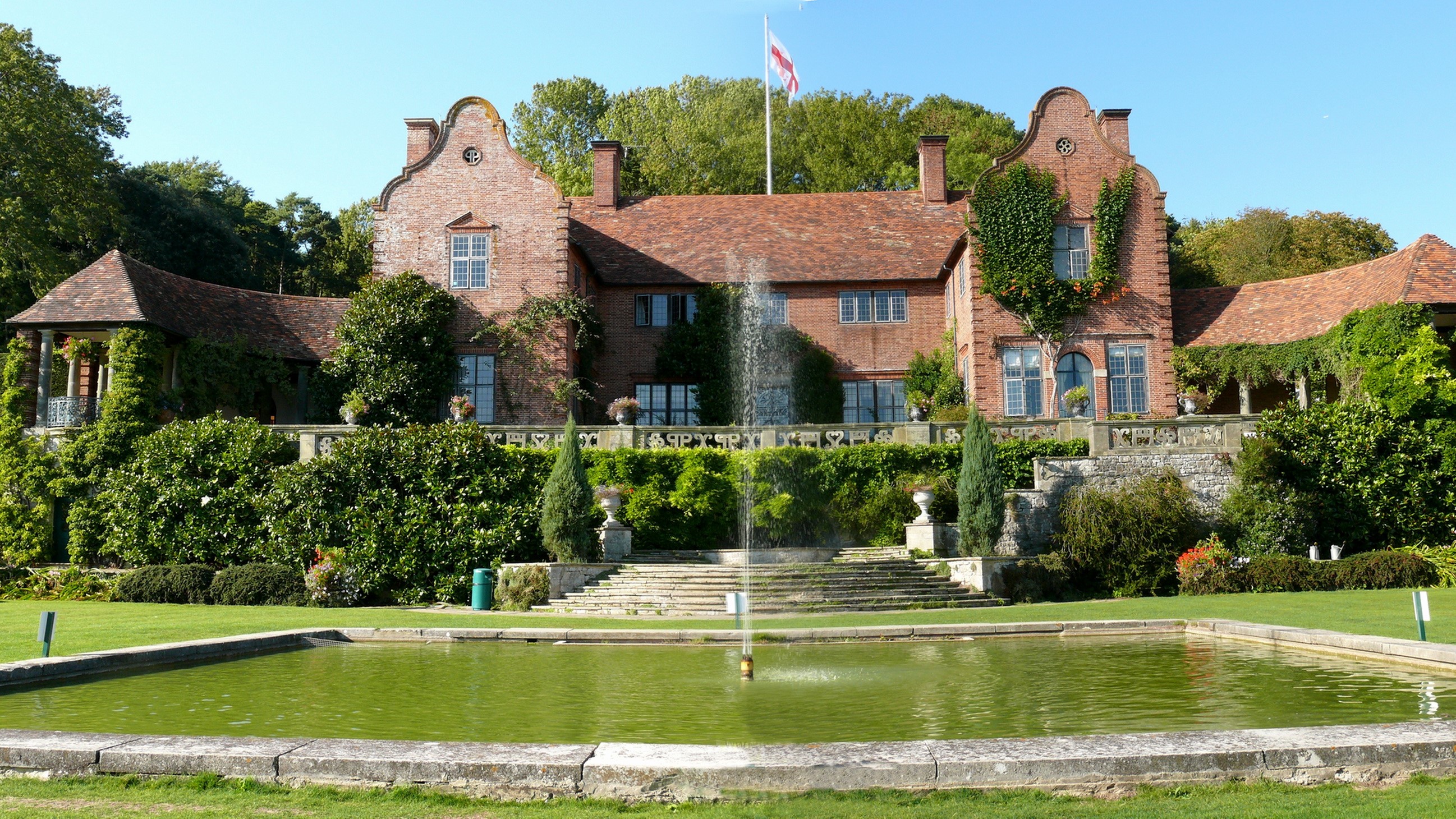 Brick house with fountain and pond in the United Kingdom HD Wallpaper