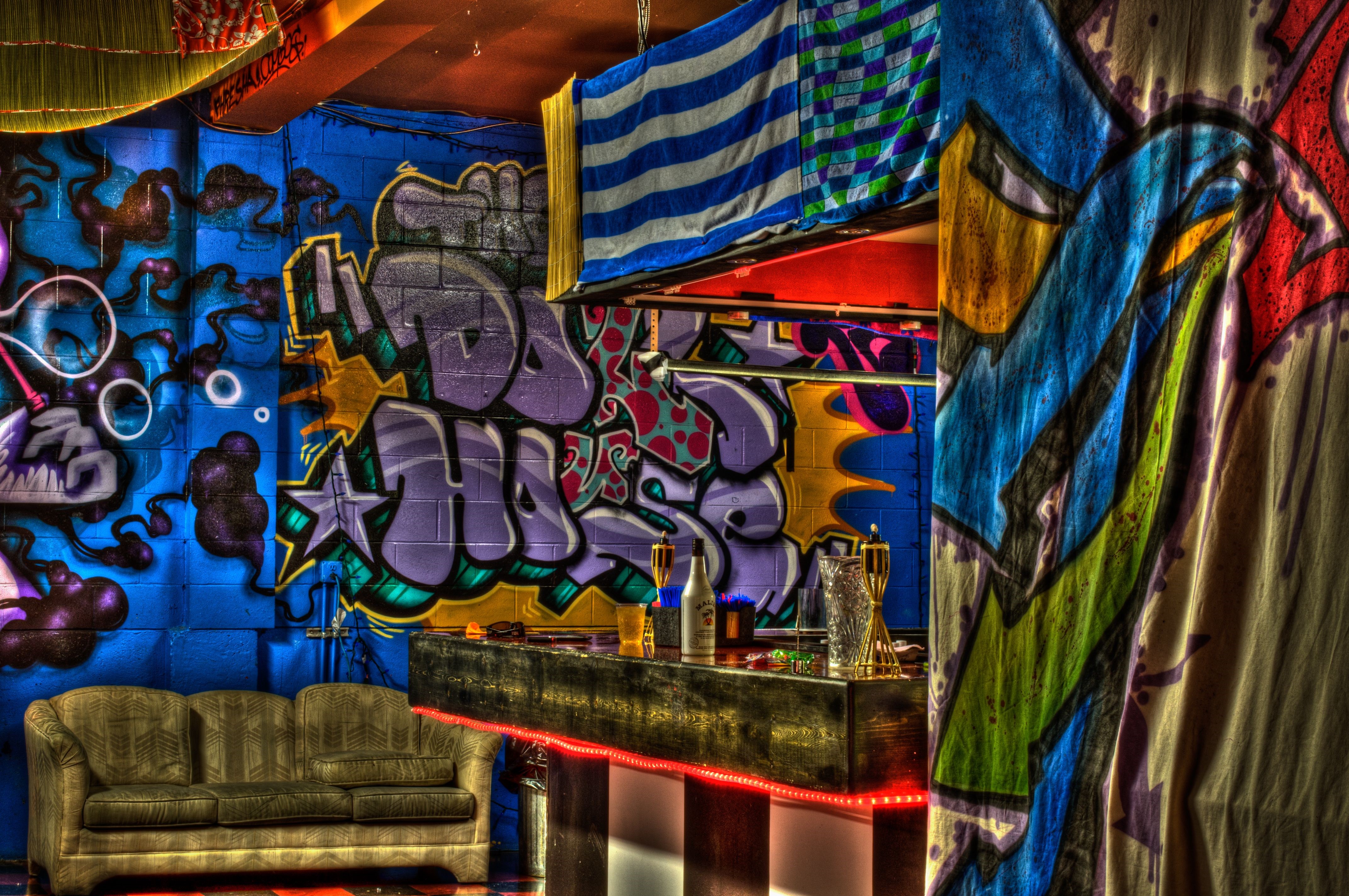 Graffiti-covered bar with a couch HD Wallpaper