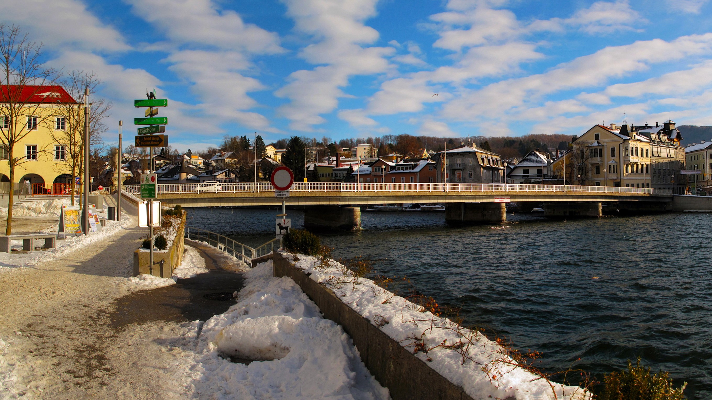 Bridge over a river in a snowy town with clouds HD Wallpaper