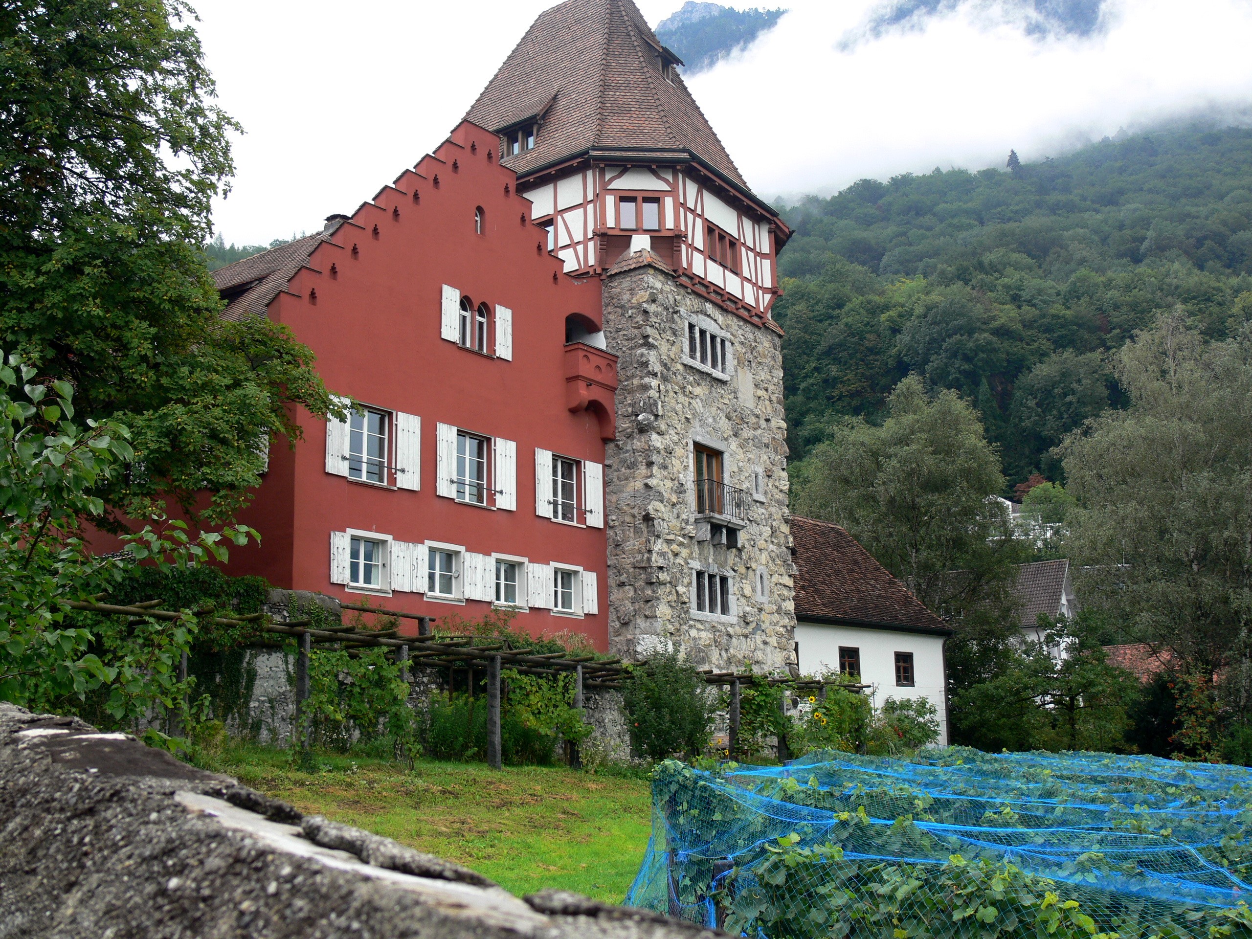 Red building with stone tower and vineyard HD Wallpaper