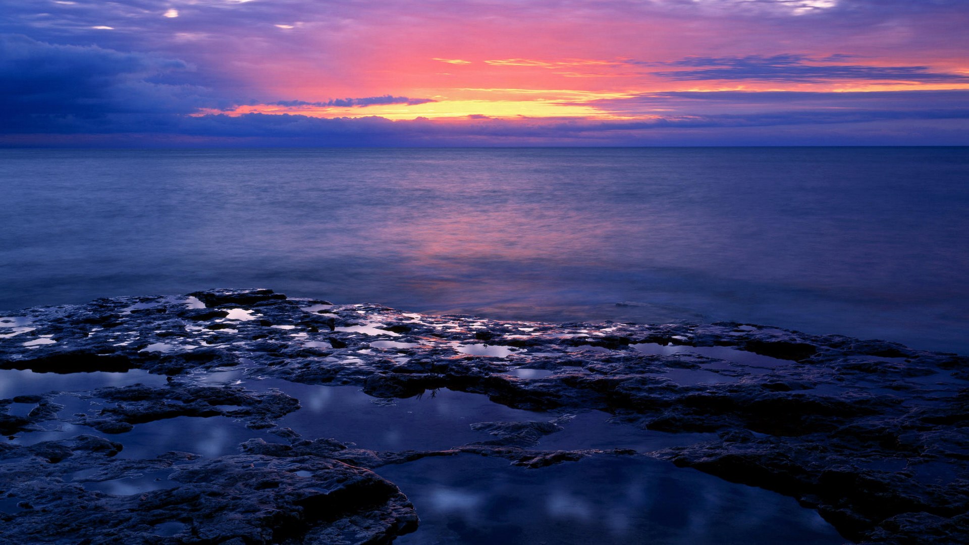 Ocean sunset with rocky shore and tide pools HD Wallpaper