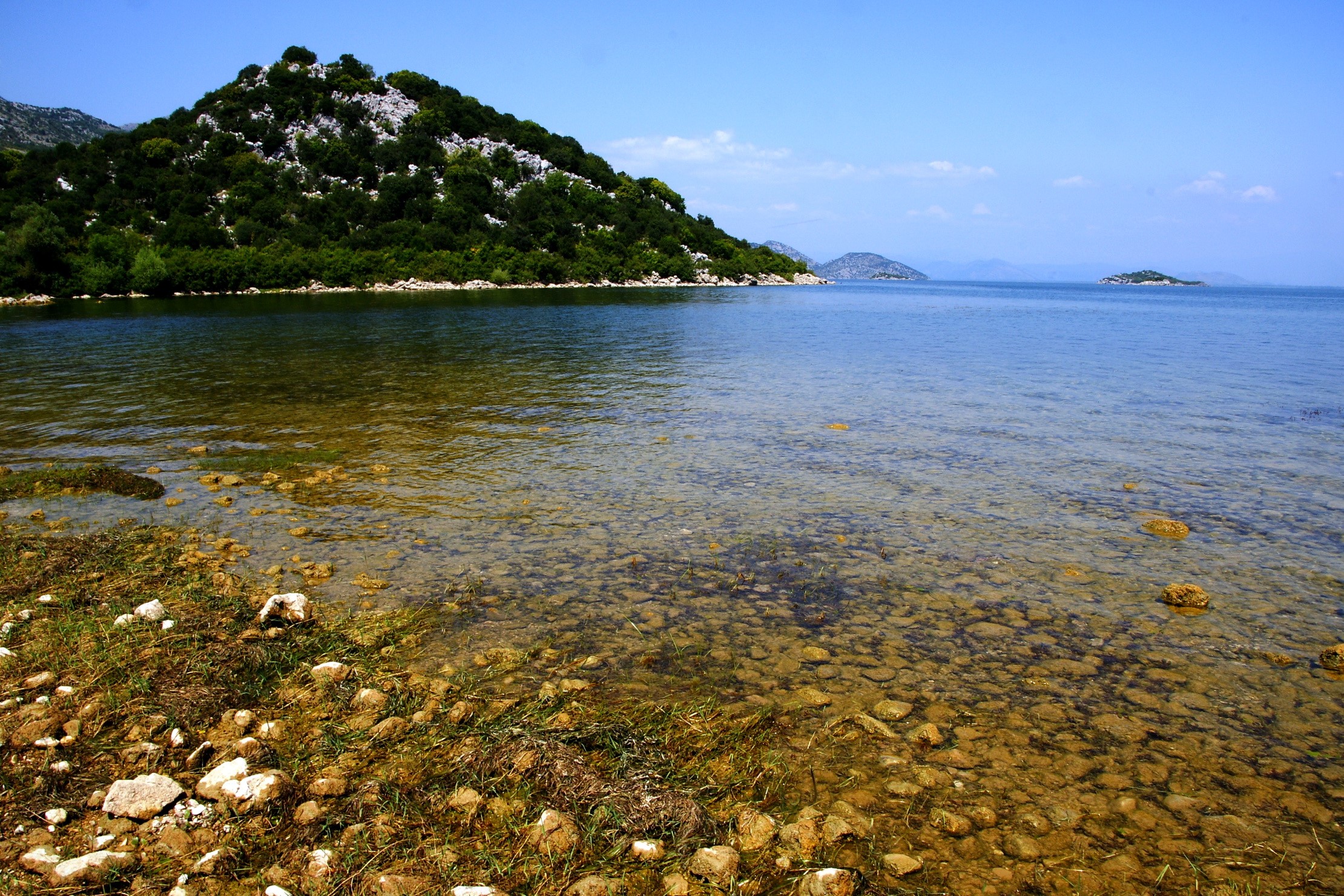 Lake with a tree-covered hill and islands HD Wallpaper