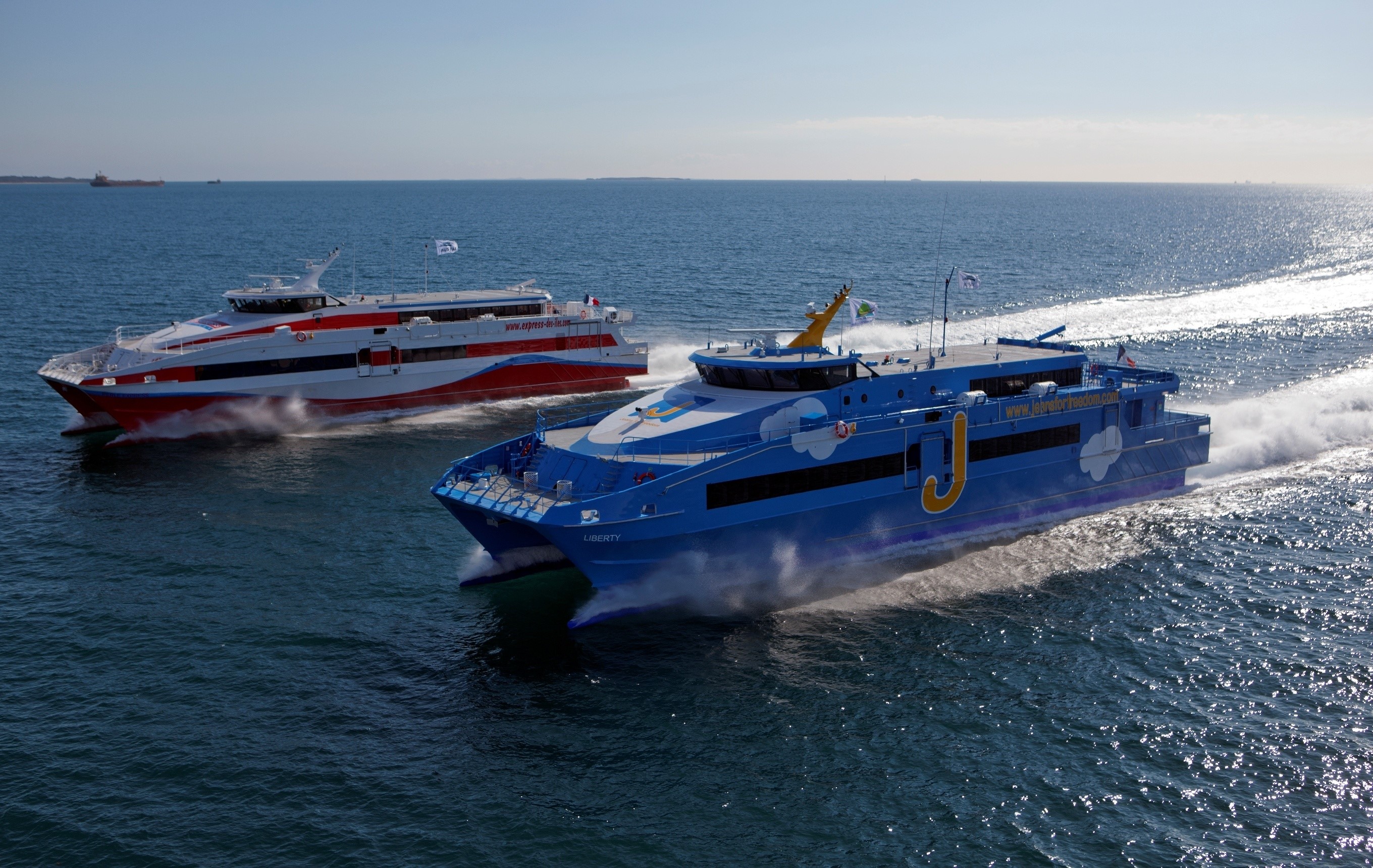 Two passenger ferries sailing on the ocean HD Wallpaper