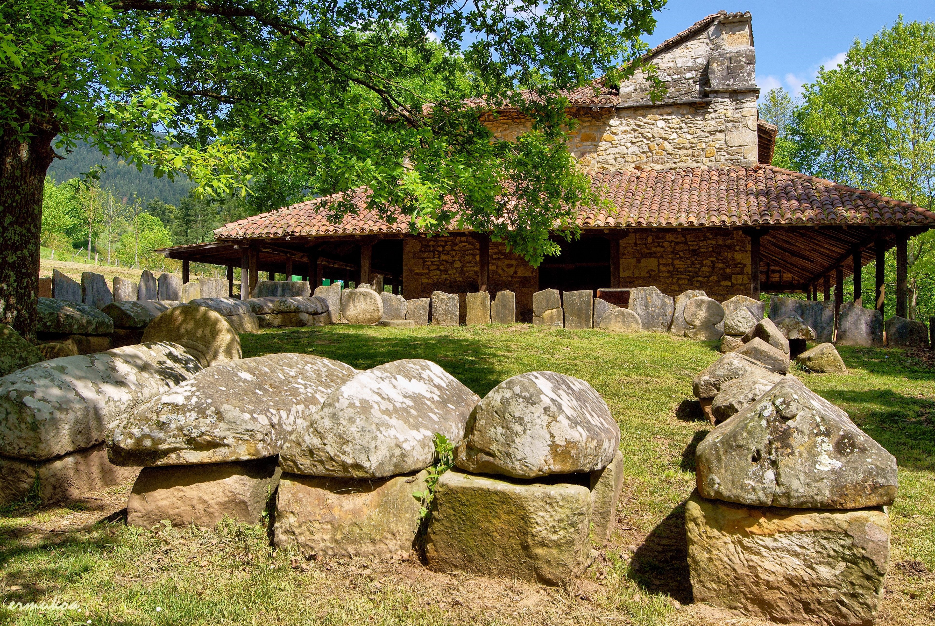 Ancient stone structures in front of a stone building in Spain HD Wallpaper