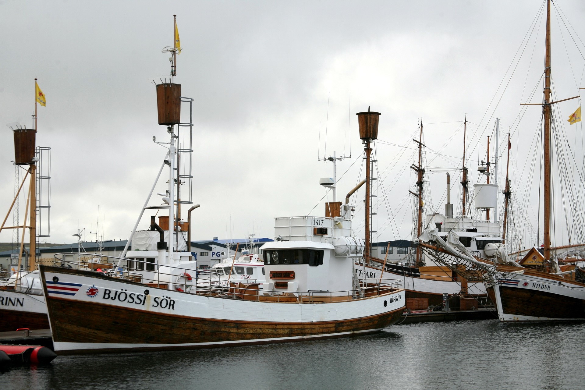 Boats docked in a harbor under a cloudy sky HD Wallpaper