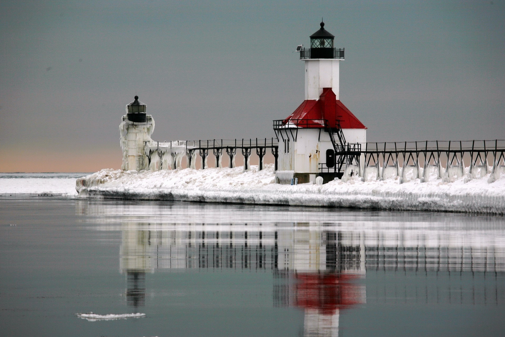 Two lighthouses on a pier covered in ice HD Wallpaper