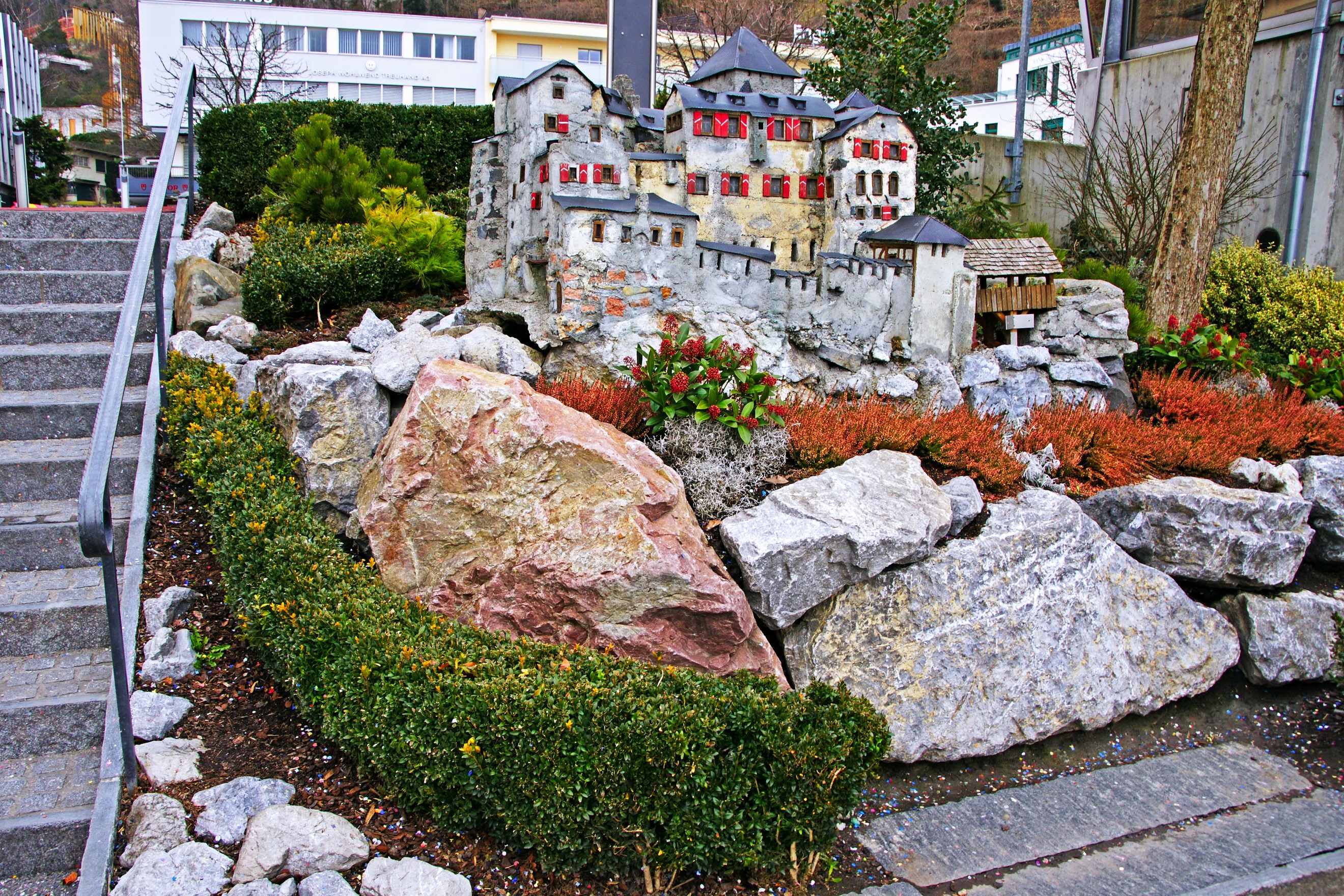 Miniature castle model in a rock garden with stairs HD Wallpaper
