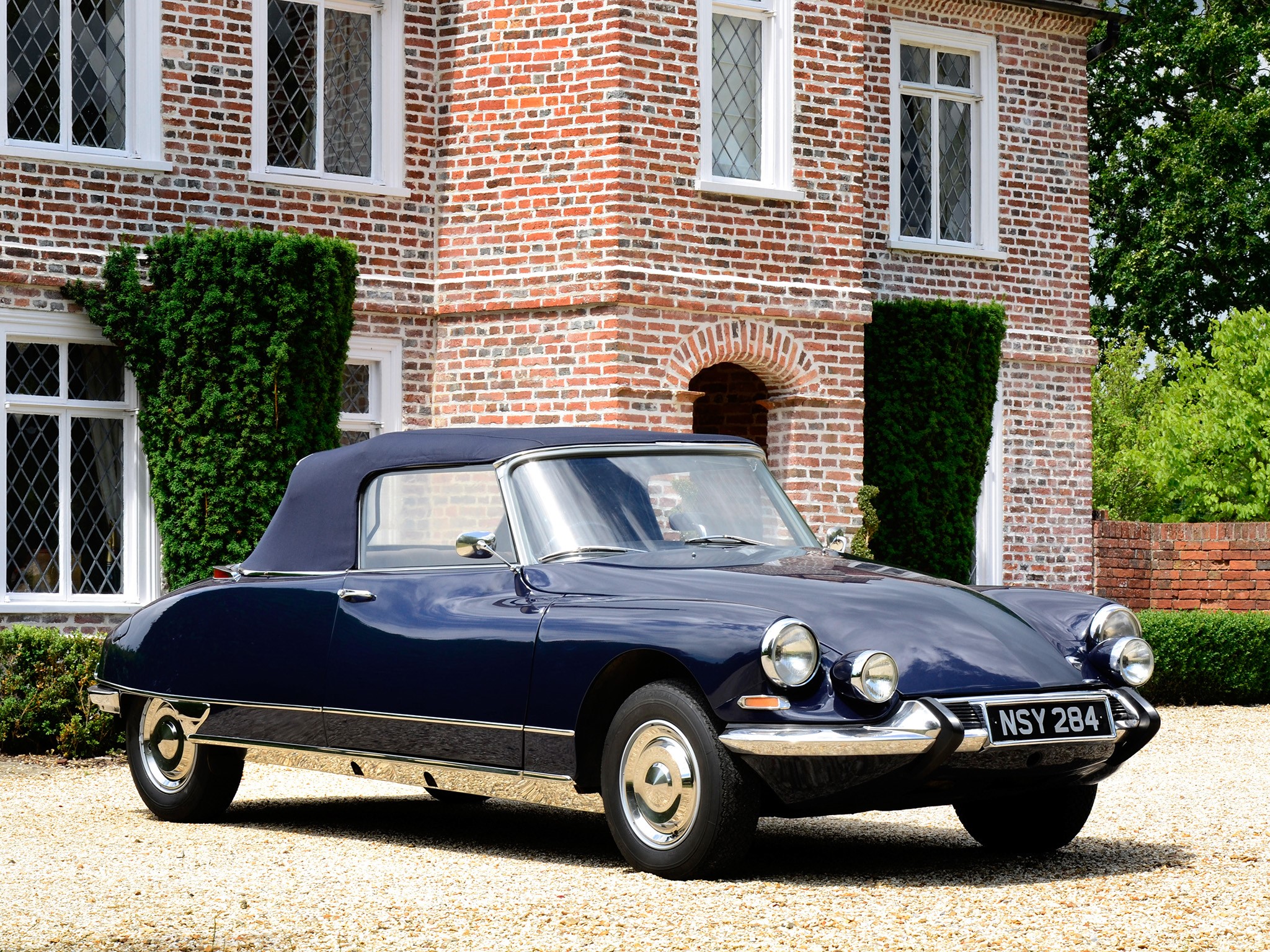 Dark blue Citroen DS convertible parked in front of a brick house HD Wallpaper