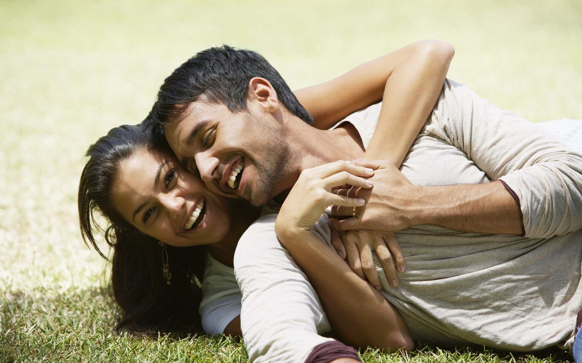 Couple laughing and hugging on grass HD Wallpaper