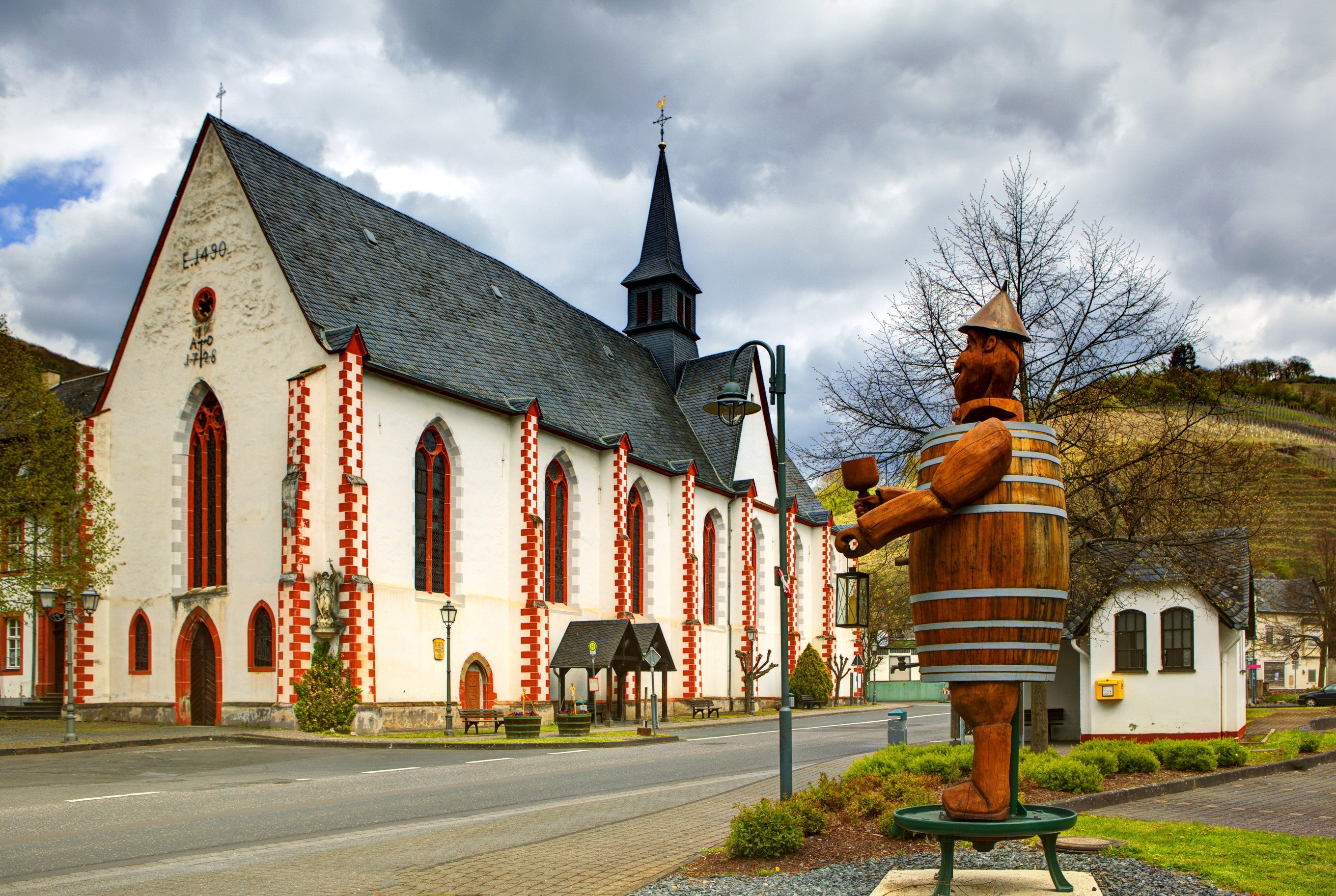 Church and wooden barrel man statue in Germany HD Wallpaper