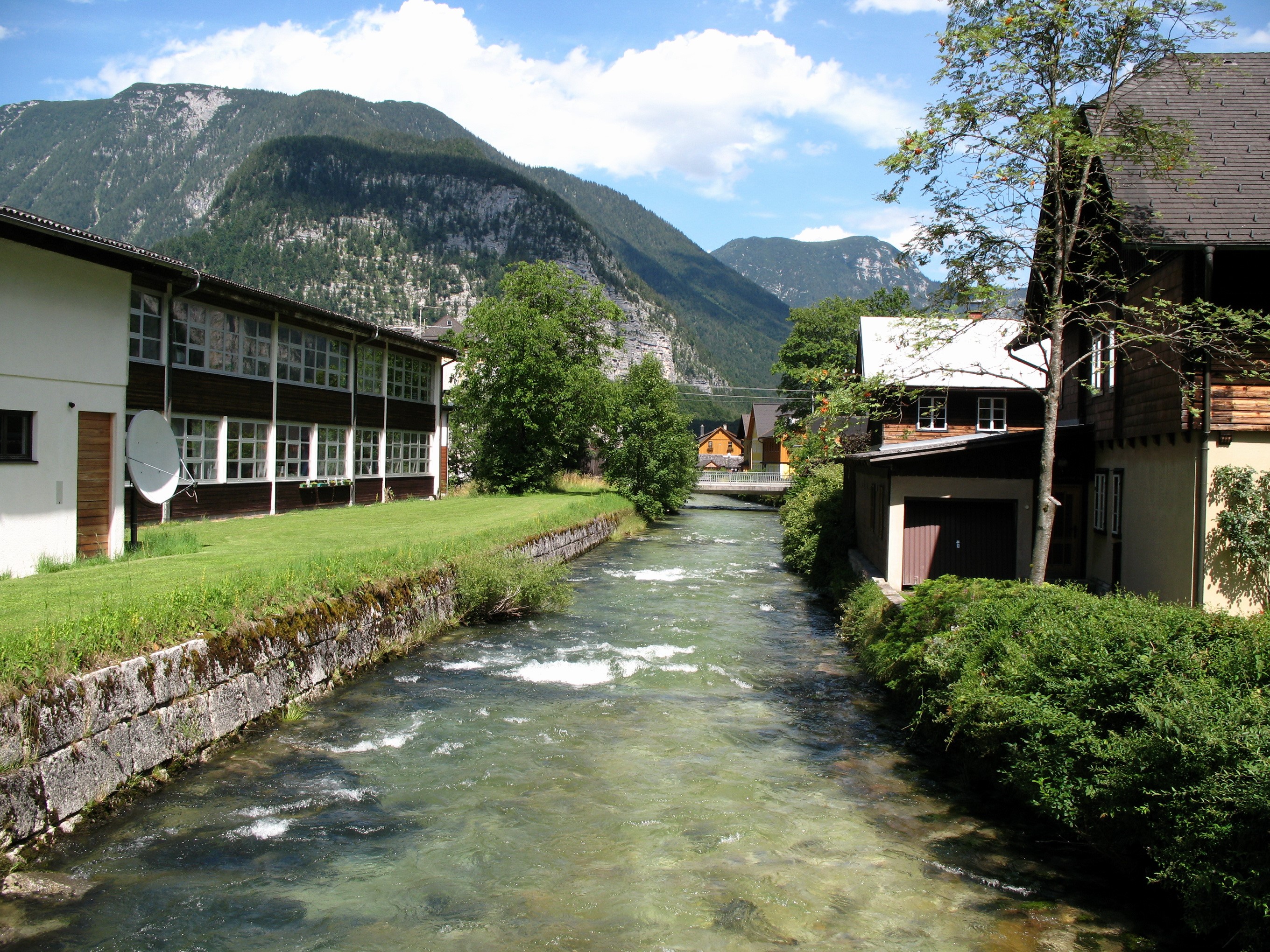 River flowing through Hallstatt, Austria with mountains HD Wallpaper