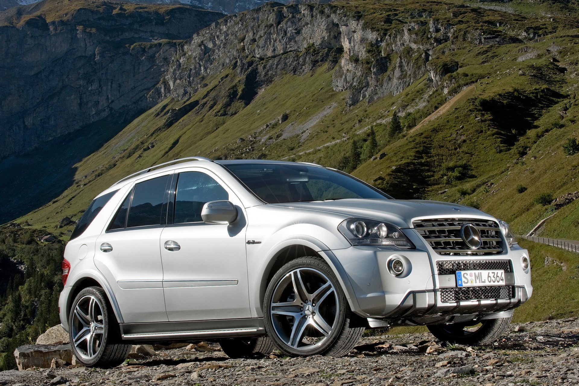 Silver Mercedes-Benz ML 63 AMG SUV on a mountain road HD Wallpaper