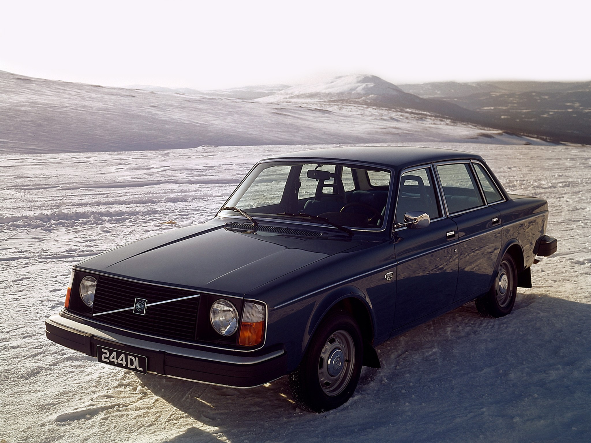 Dark blue Volvo 244 DL parked in a snowy landscape HD Wallpaper