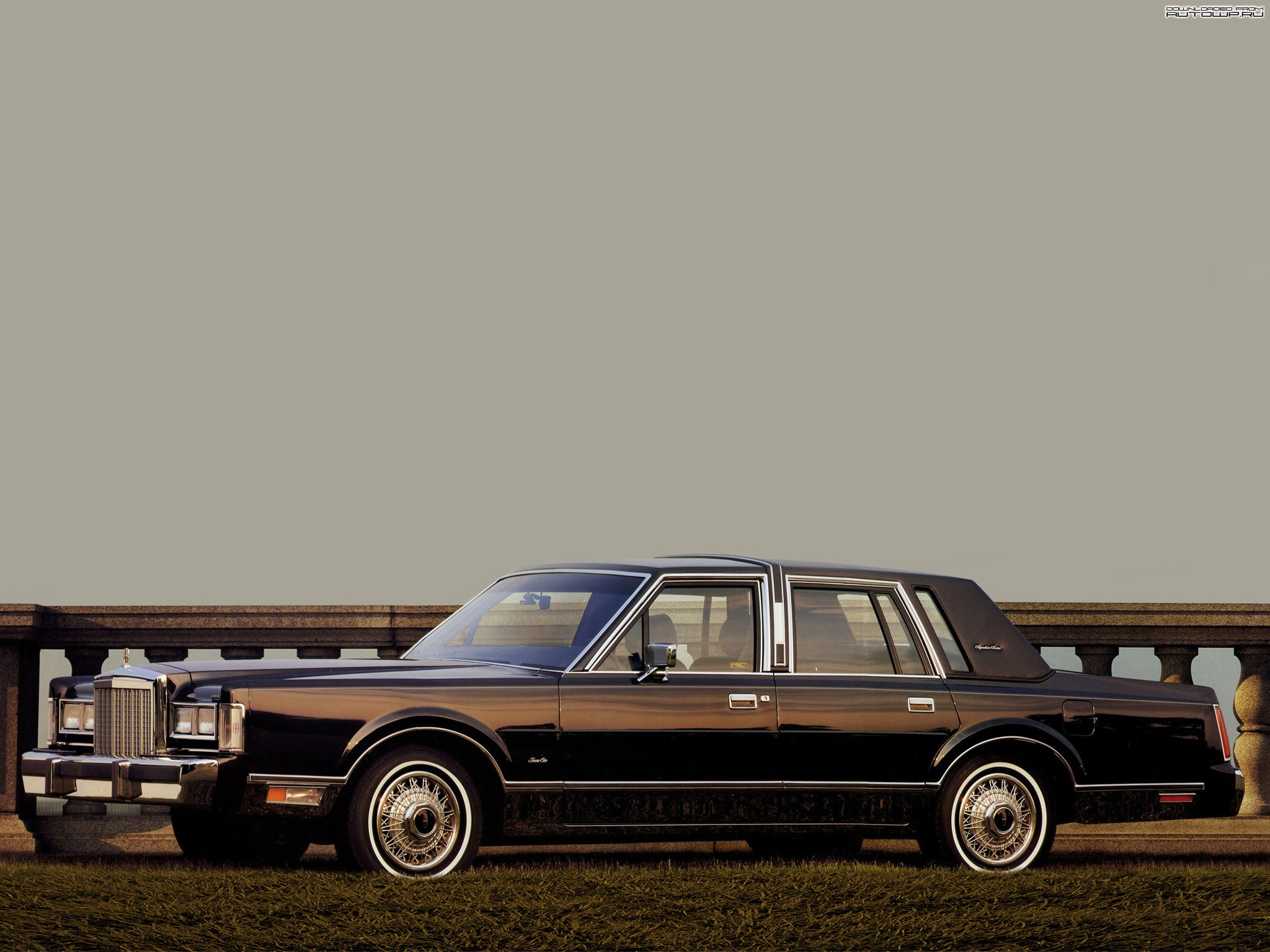 Black Lincoln Town Car parked by a stone wall HD Wallpaper