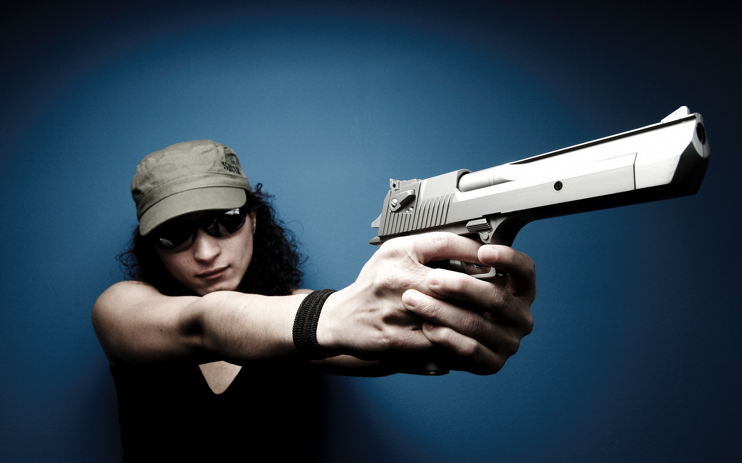 Woman in sunglasses and cap holding a pistol HD Wallpaper