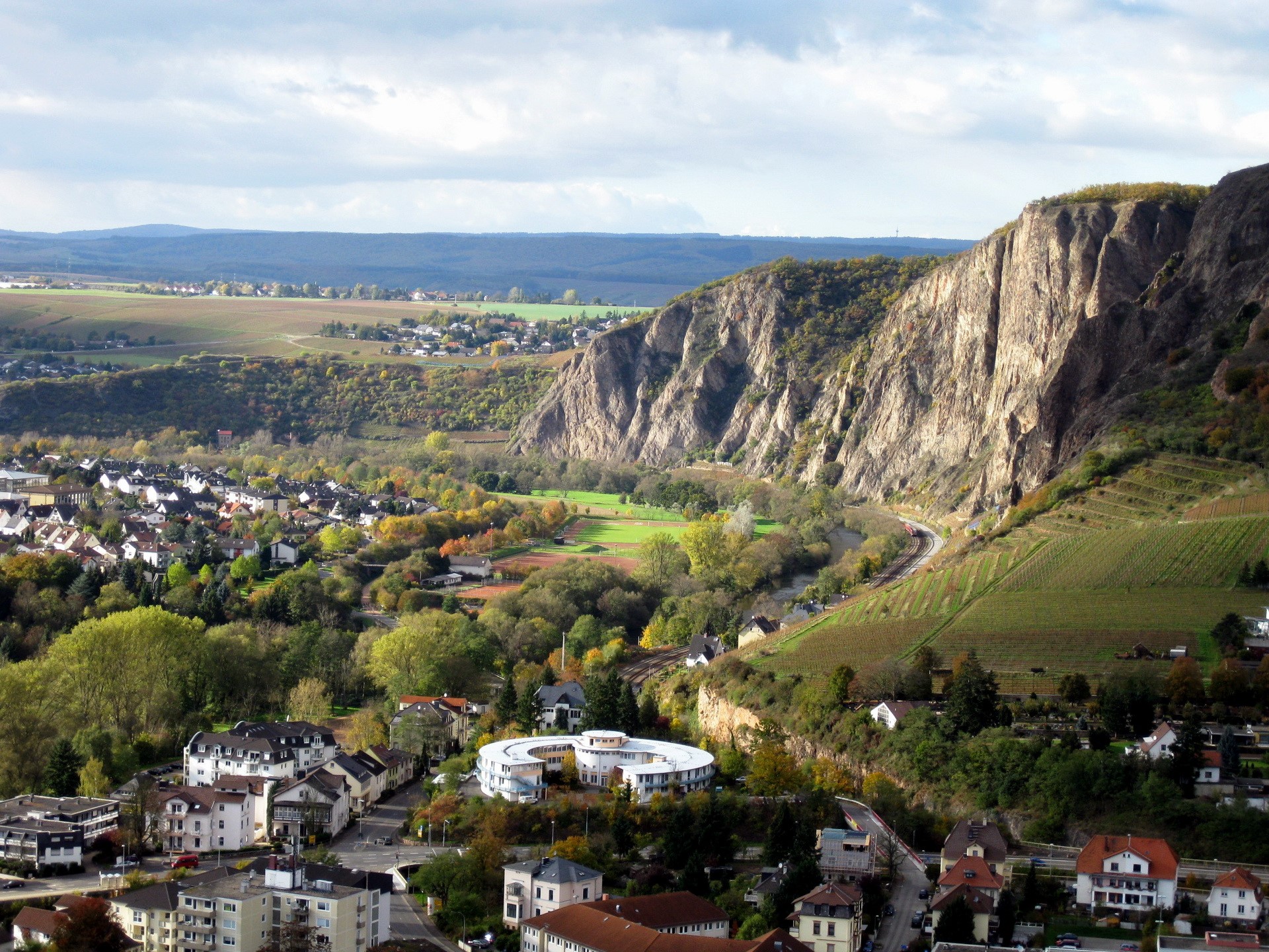 View of a town nestled beside a rocky mountain in Germany HD Wallpaper