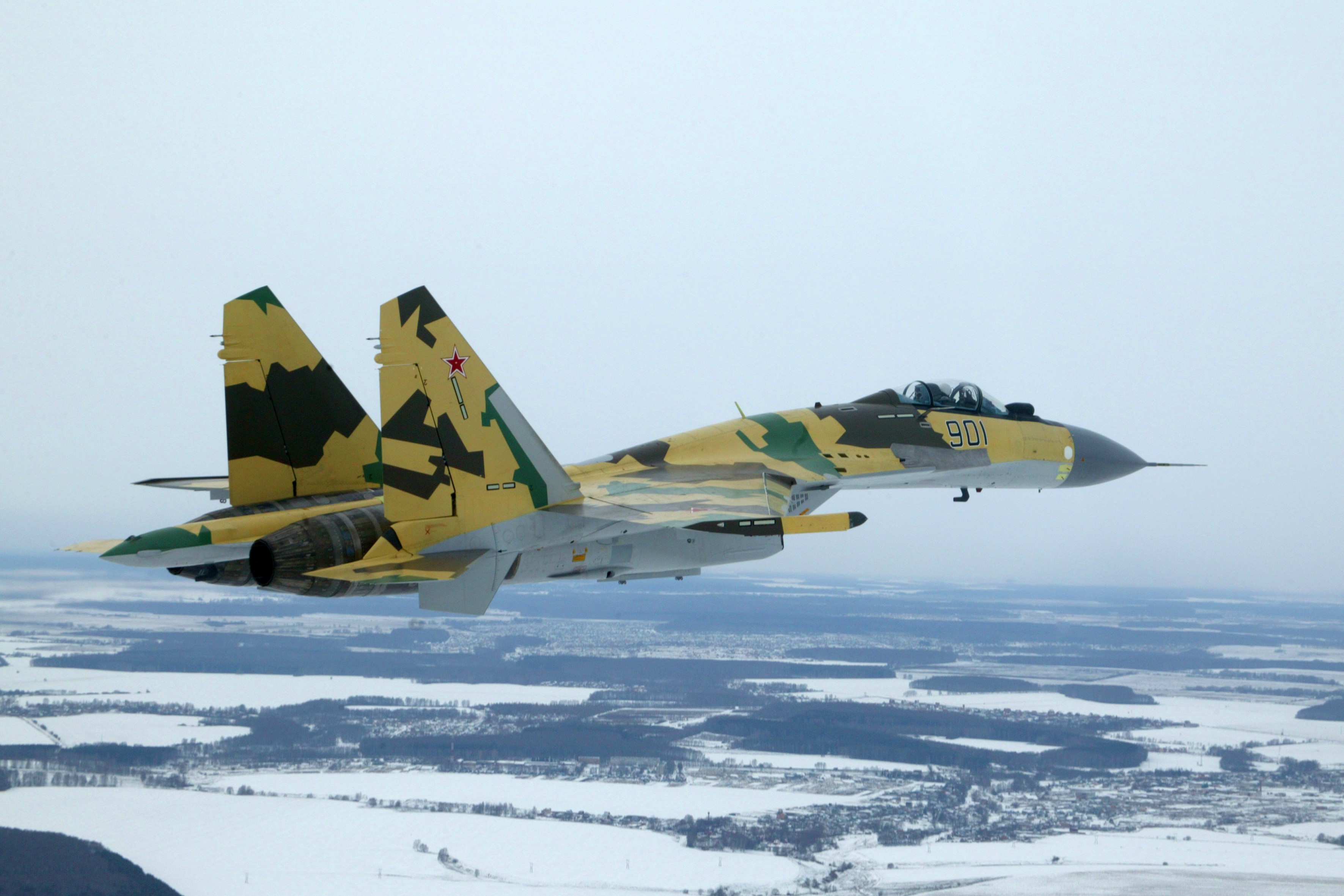 Sukhoi Su-35 fighter jet in flight over a snowy landscape HD Wallpaper