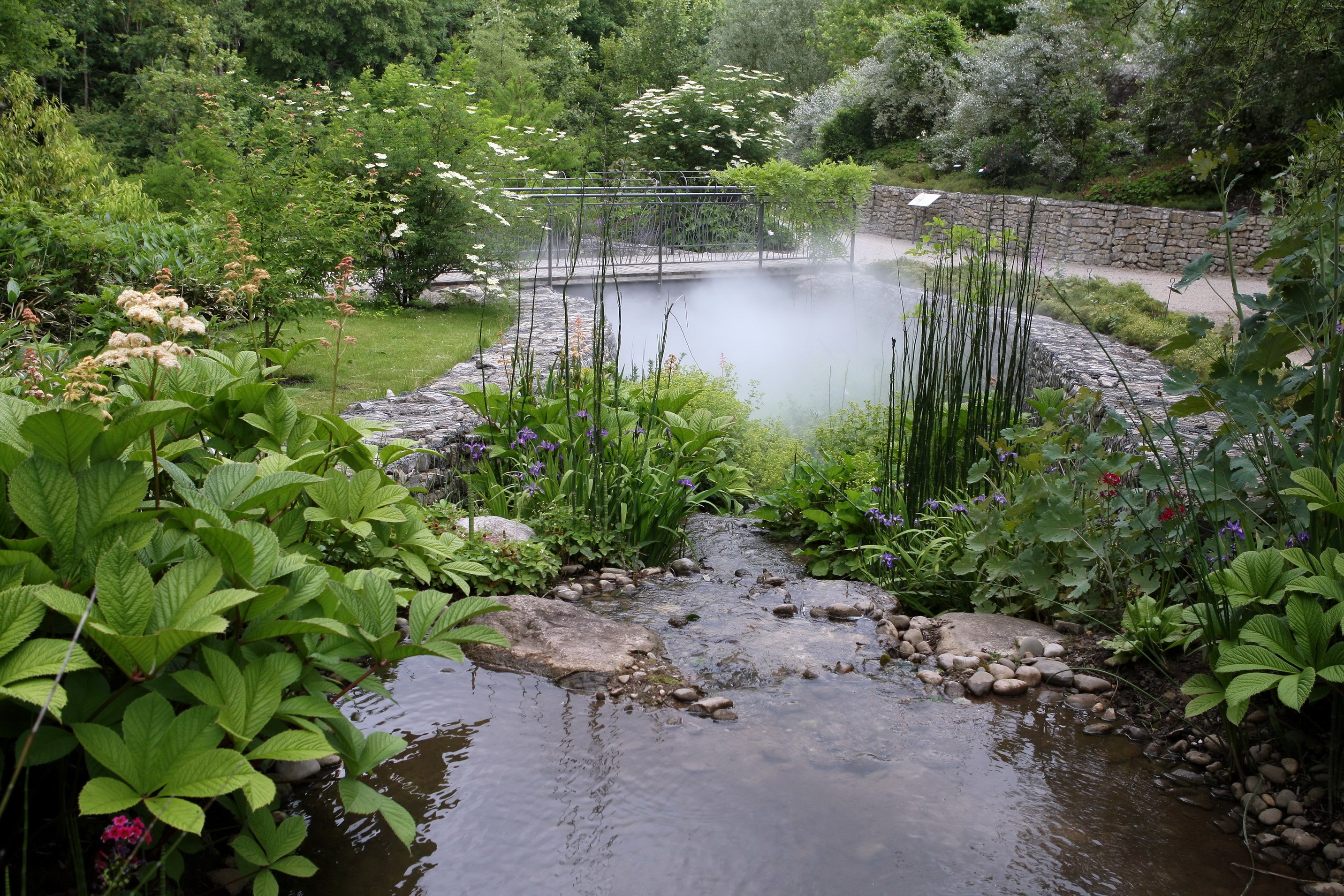 Garden pond with a small stream and bridge HD Wallpaper