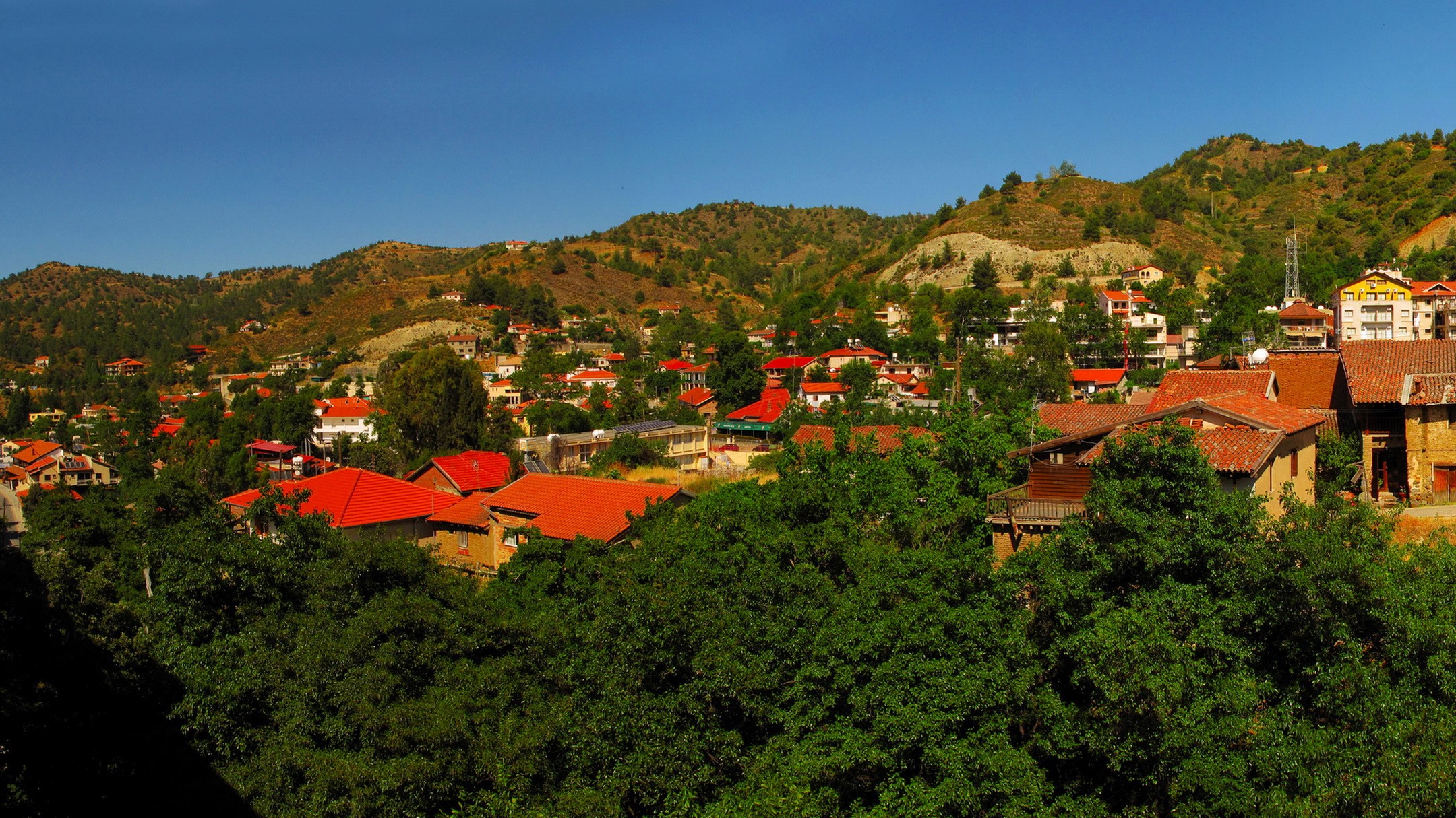 Village nestled in a mountainous landscape HD Wallpaper