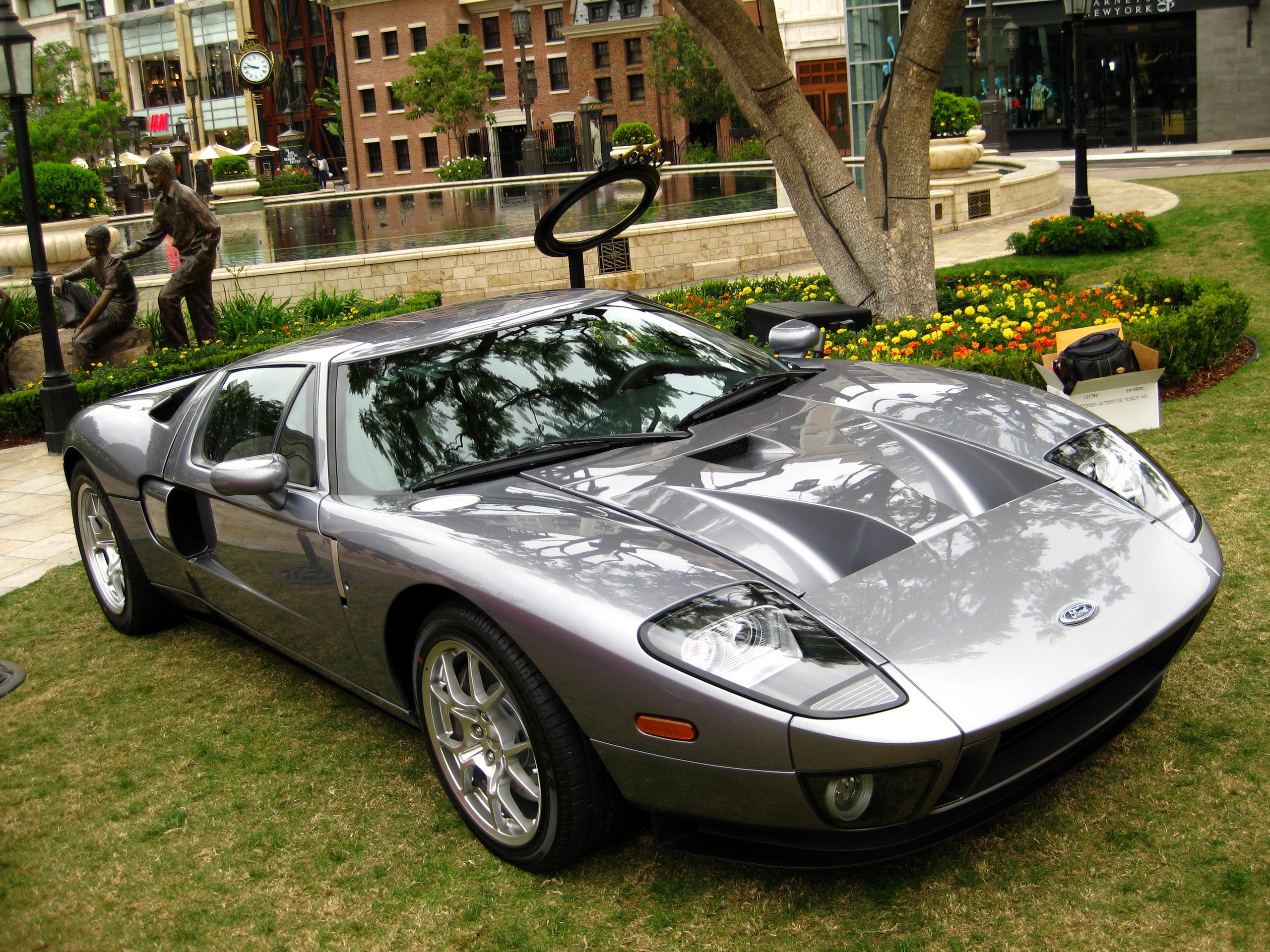Silver Ford GT parked on grass with buildings in background HD Wallpaper
