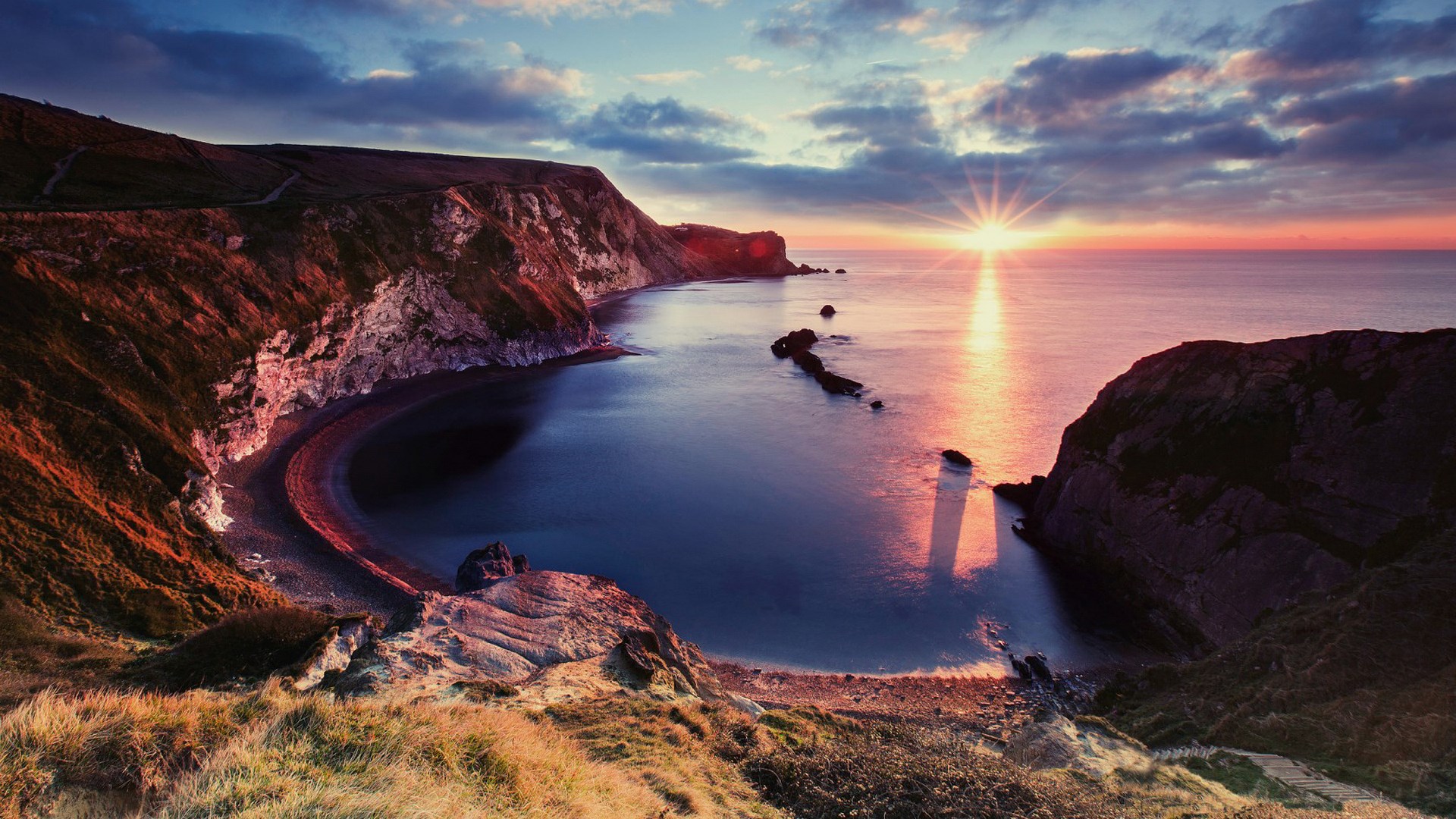 Sunset over a rocky cove with cliffs and sea stacks HD Wallpaper