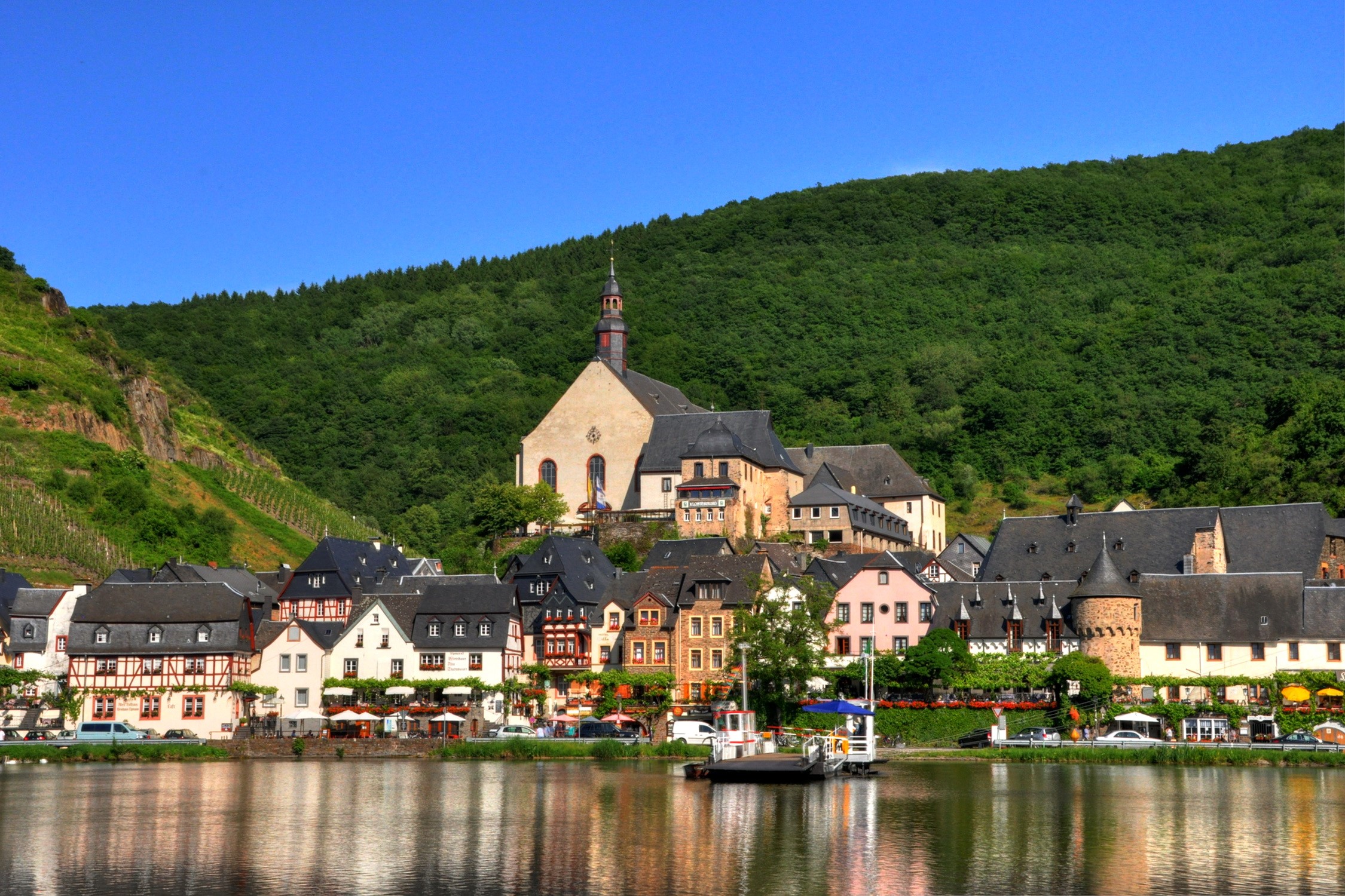 Riverfront town with church and vineyards in Germany HD Wallpaper