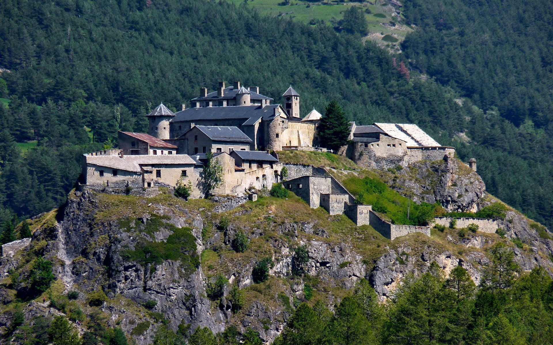 Fortress on a rocky outcrop surrounded by forest HD Wallpaper