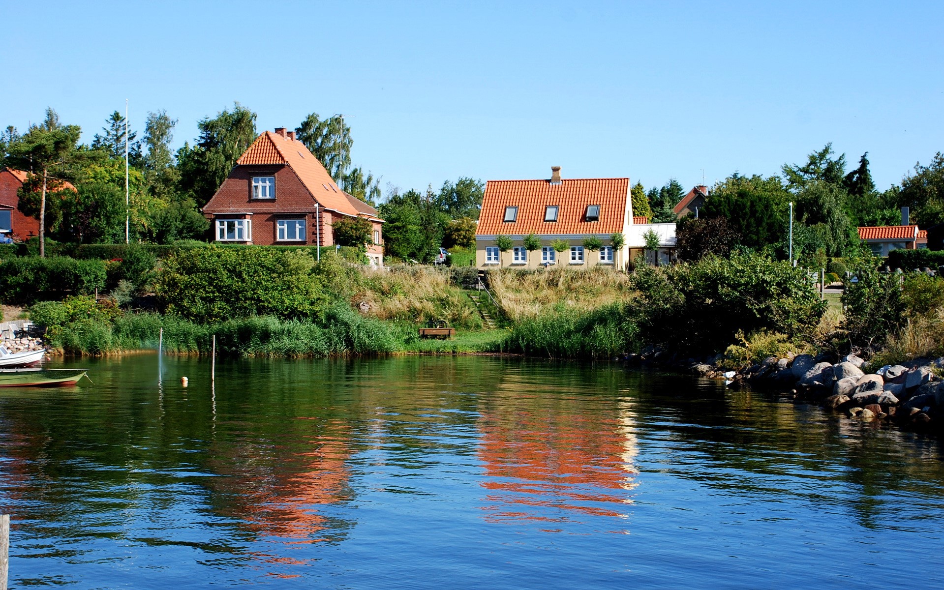 Houses on a hill overlooking a body of water in Denmark HD Wallpaper