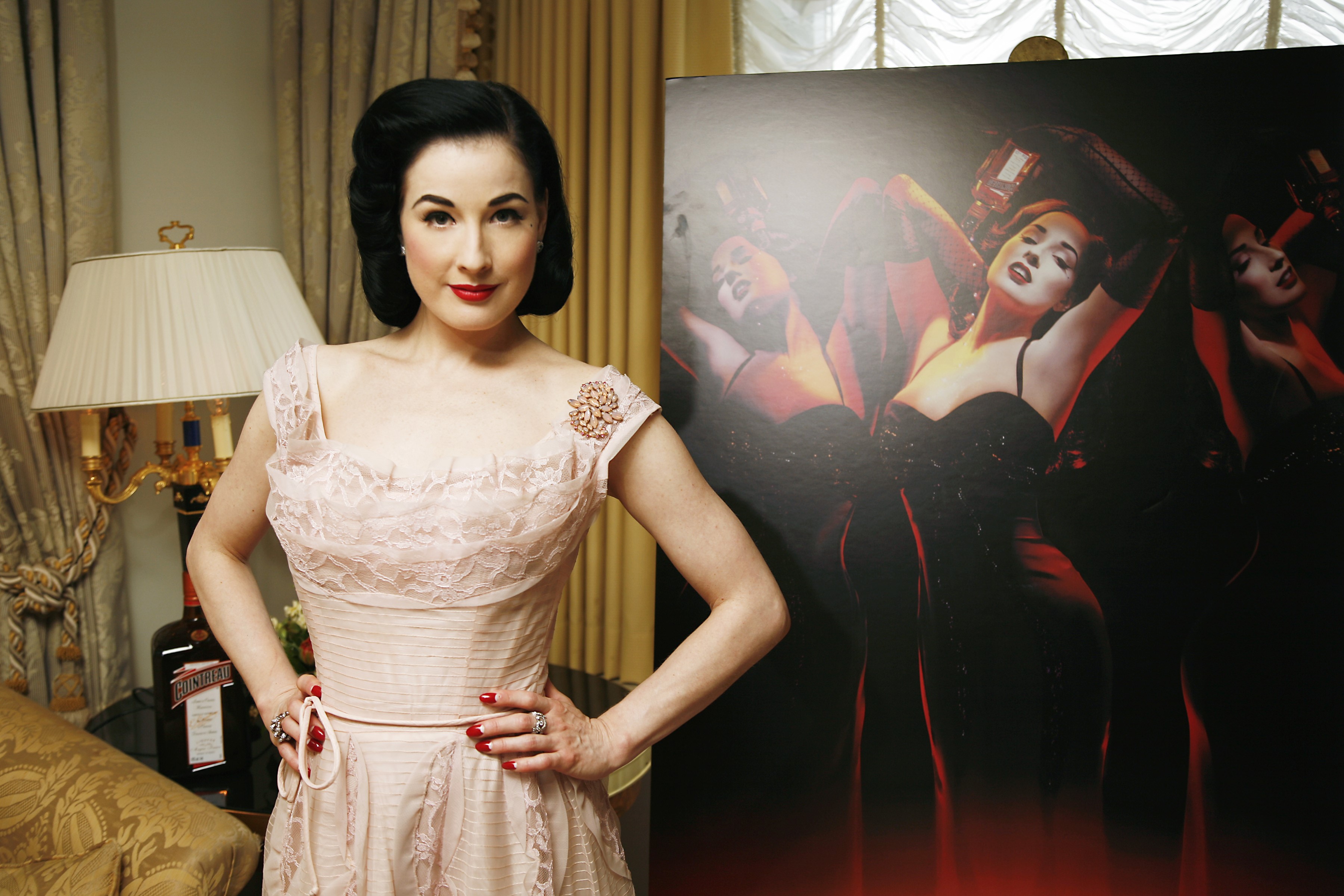 Dita Von Teese posing next to a large portrait HD Wallpaper