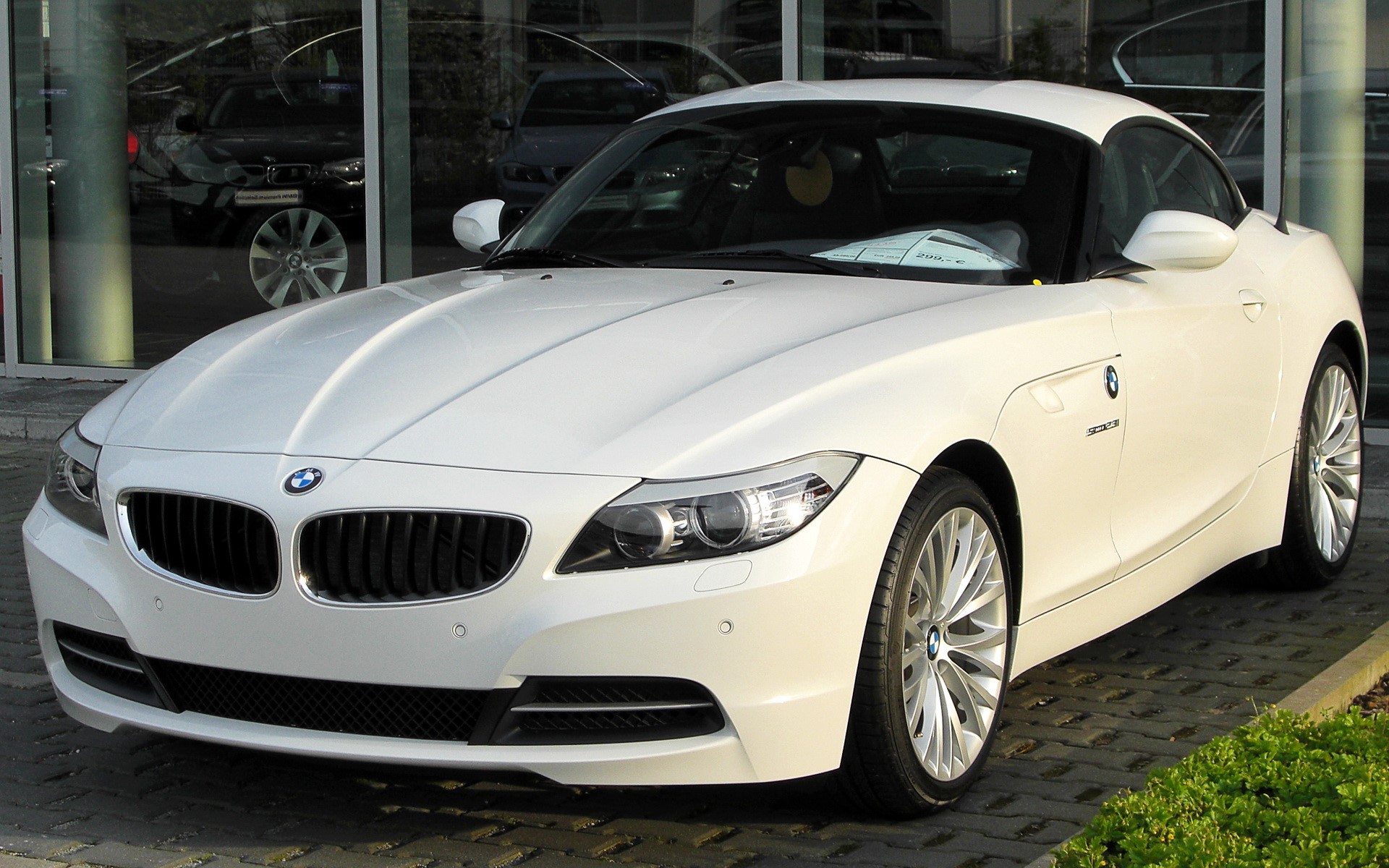 White BMW Z4 parked outside a dealership HD Wallpaper