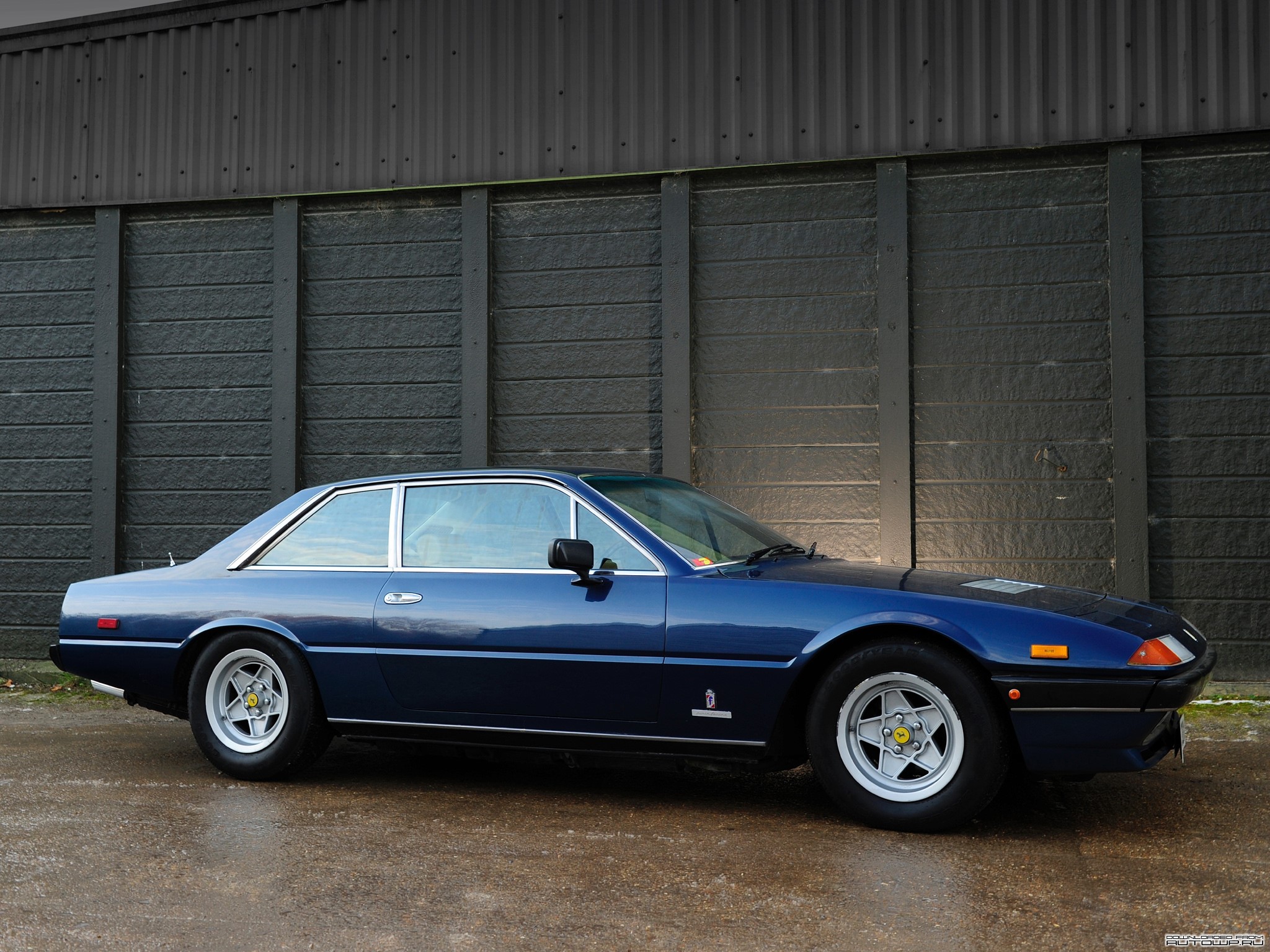 Blue Ferrari parked in front of a dark wall HD Wallpaper